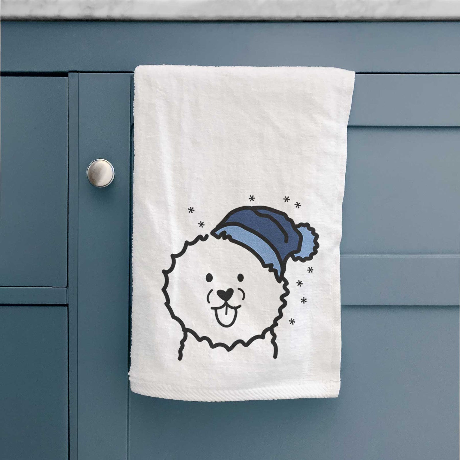 Minimalist line drawing of a Bichon Frise wearing a winter beanie on a decorative hand towel