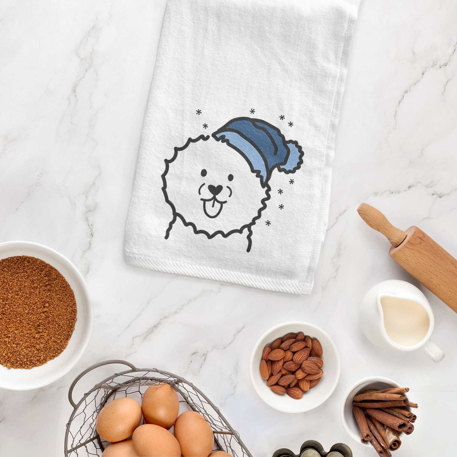 Minimalist line drawing of a Bichon Frise wearing a winter beanie on a decorative hand towel
