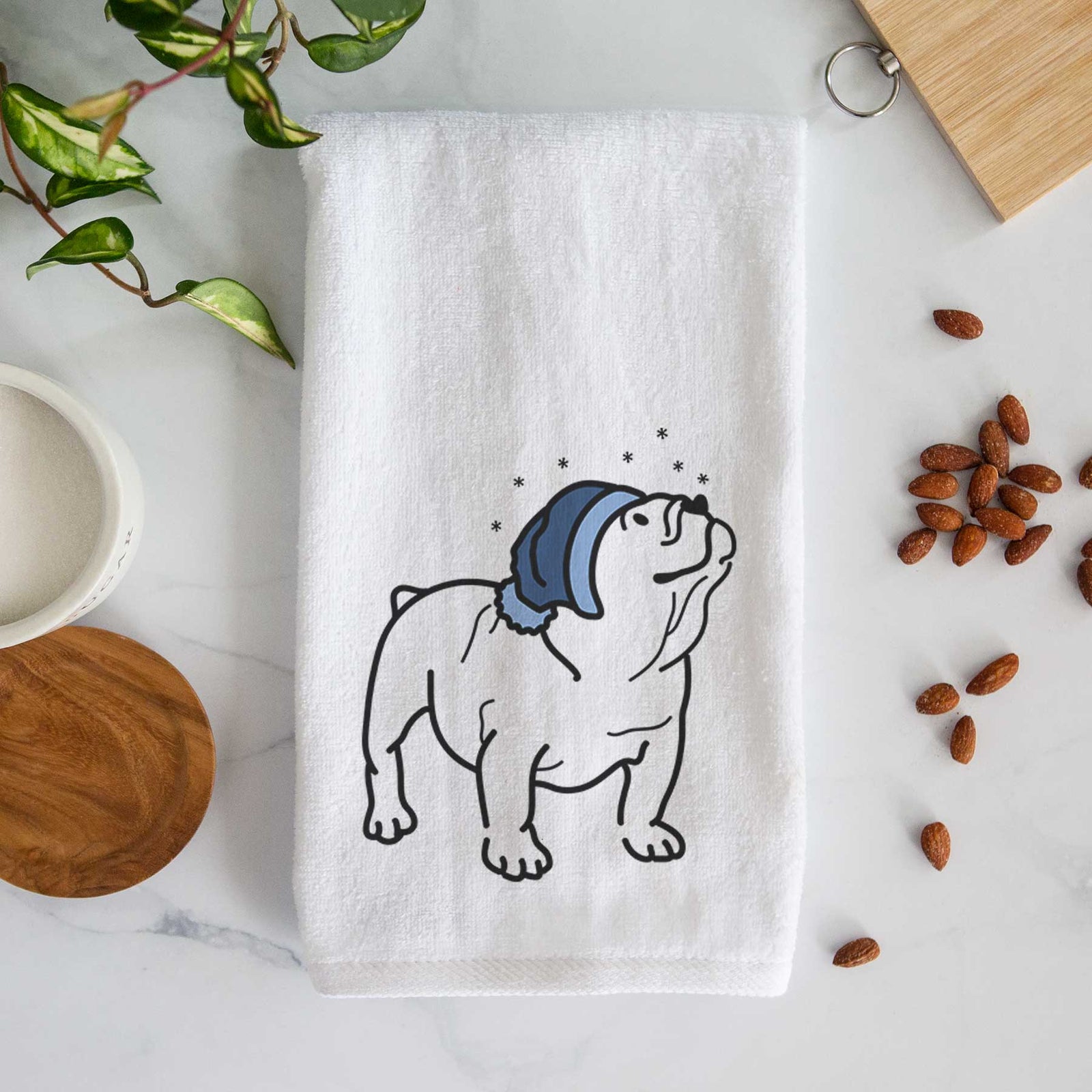 Minimalist line drawing of Bruno the English Bulldog wearing a winter beanie on a decorative hand towel