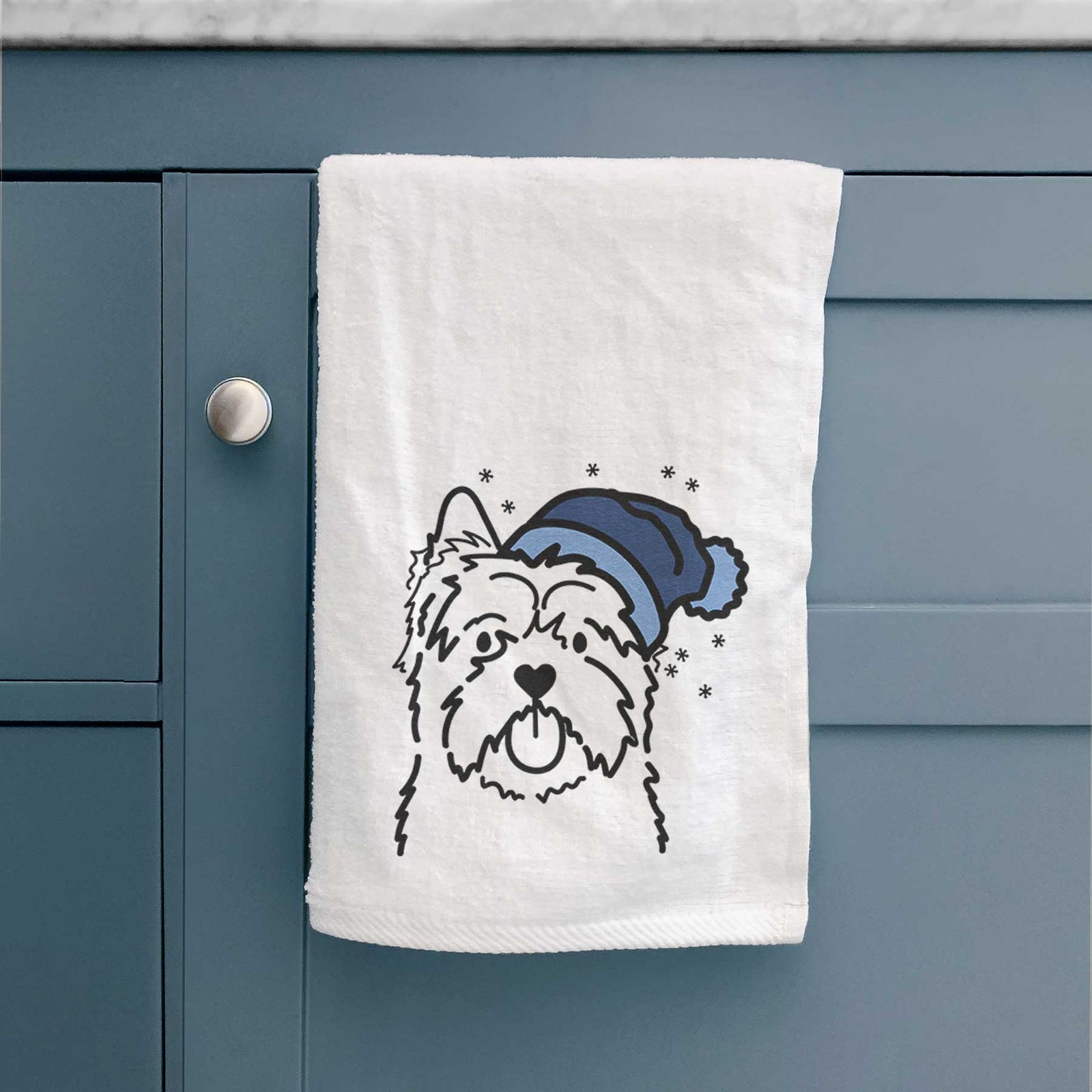 Minimalist line drawing of a Cairn Terrier wearing a winter beanie on a decorative hand towel