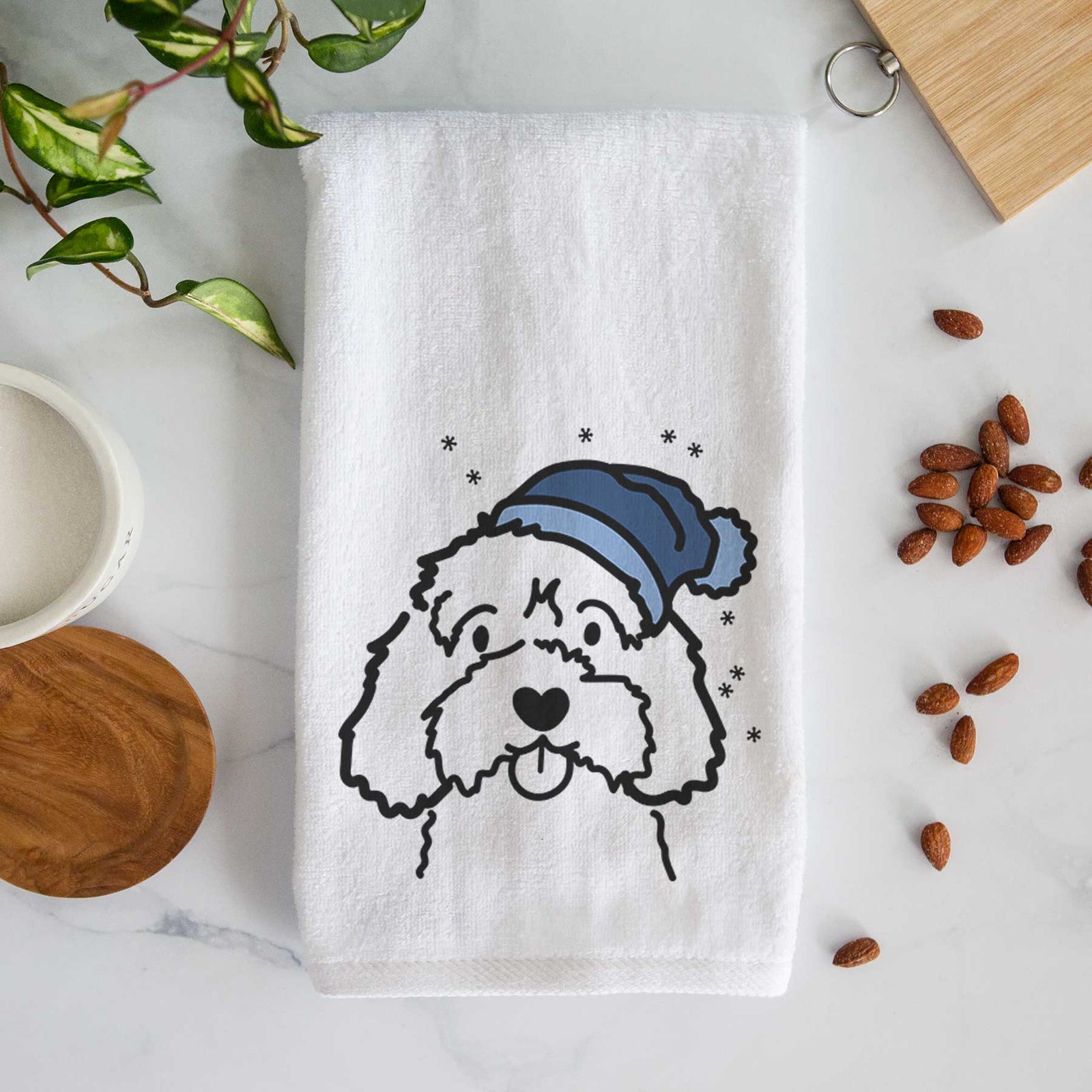 Minimalist line drawing of a Cavapoo wearing a winter beanie on a decorative hand towel