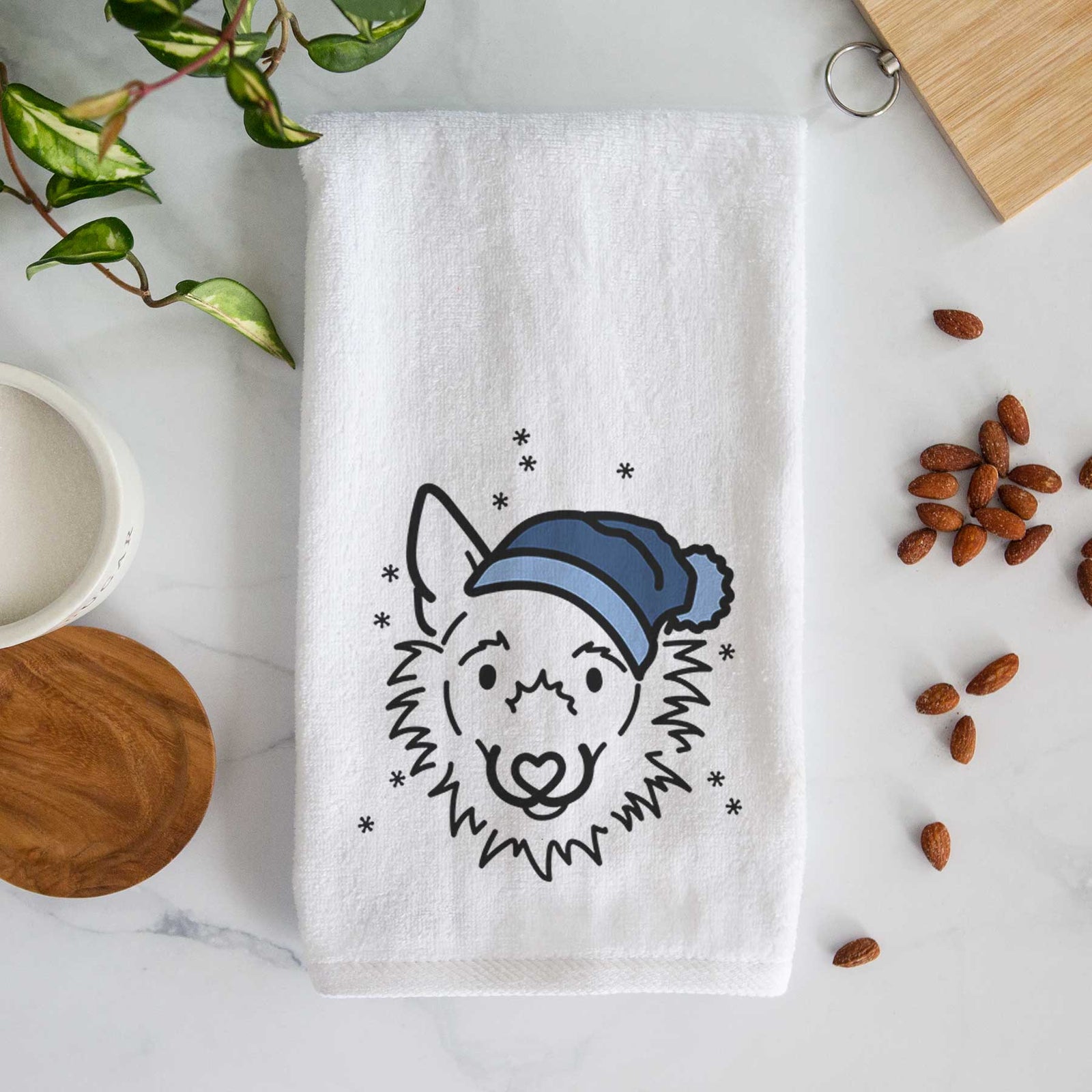 Minimalist line drawing of Chewy the Super Mutt wearing a winter beanie on a decorative hand towel