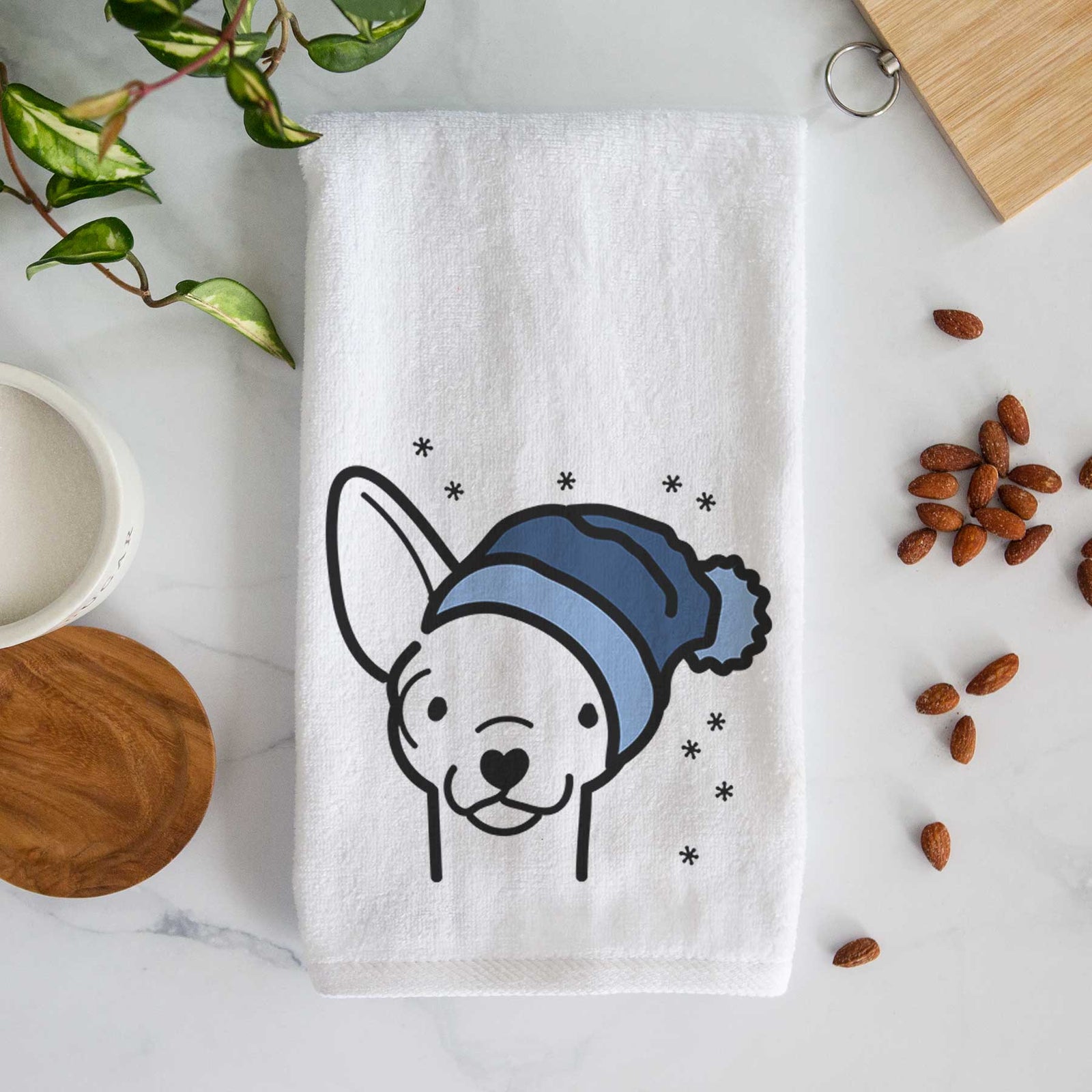 Minimalist line drawing of a Chihuahua wearing a winter beanie on a decorative hand towel