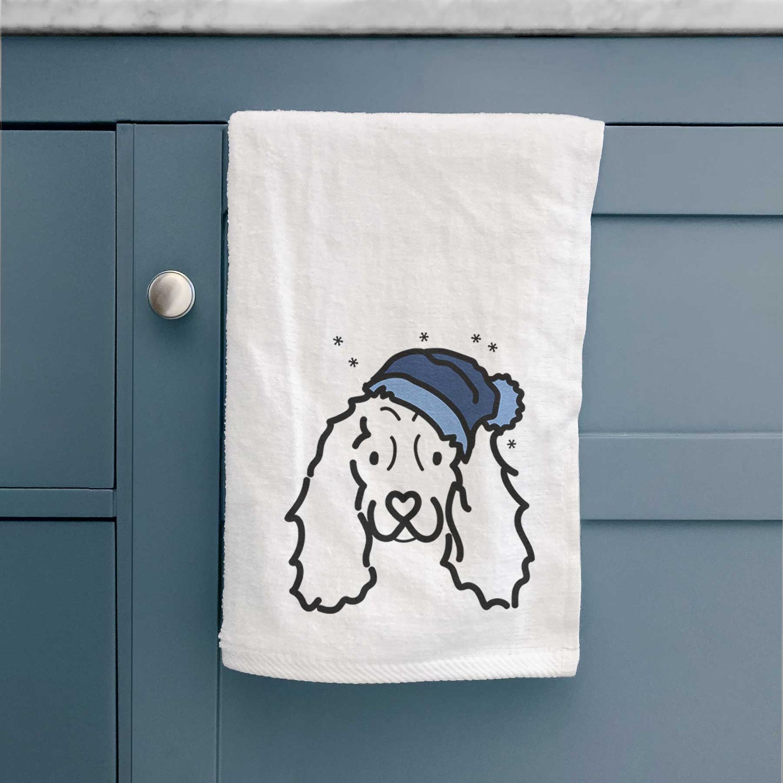Minimalist line drawing of an American Cocker Spaniel wearing a winter beanie on a decorative hand towel