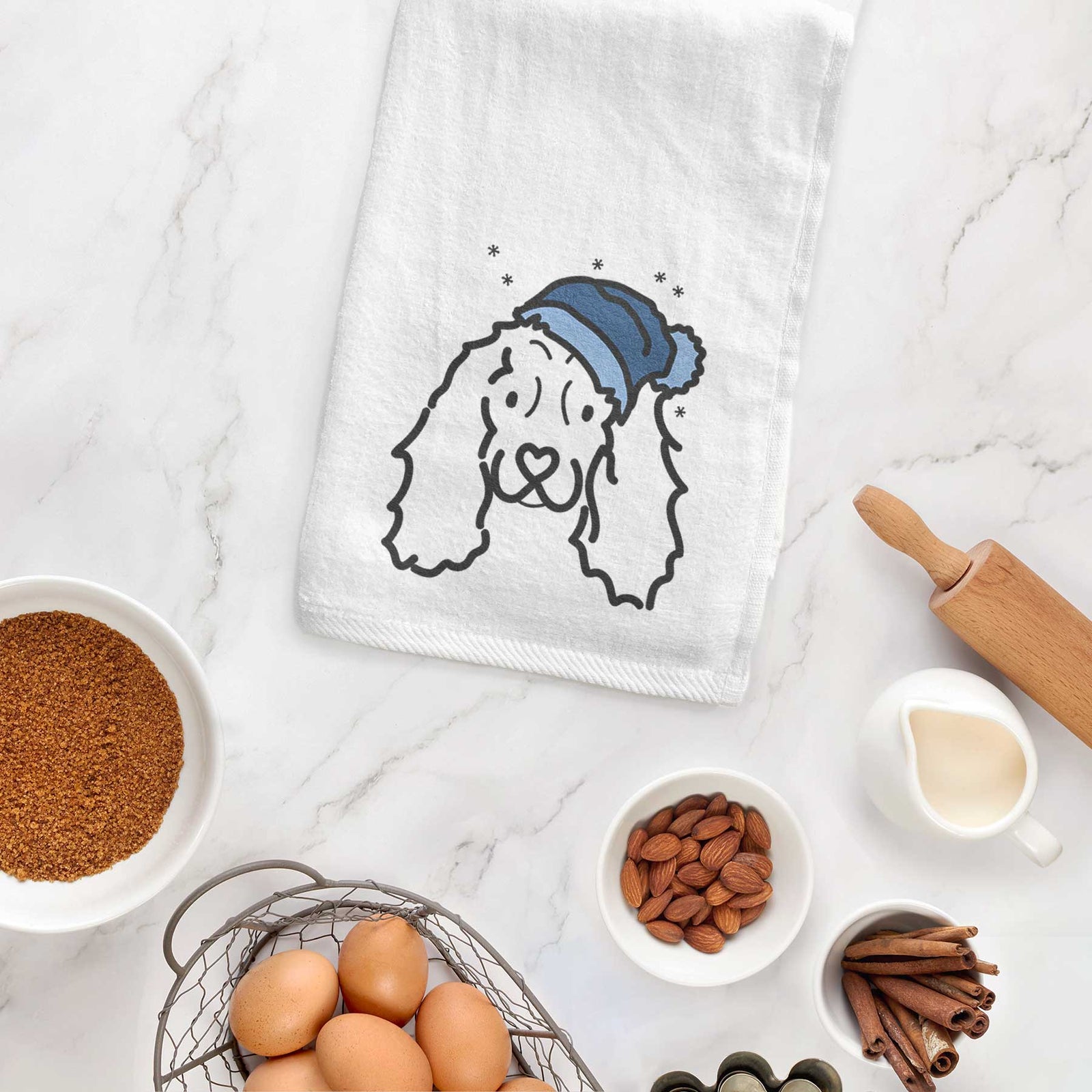 Minimalist line drawing of an American Cocker Spaniel wearing a winter beanie on a decorative hand towel