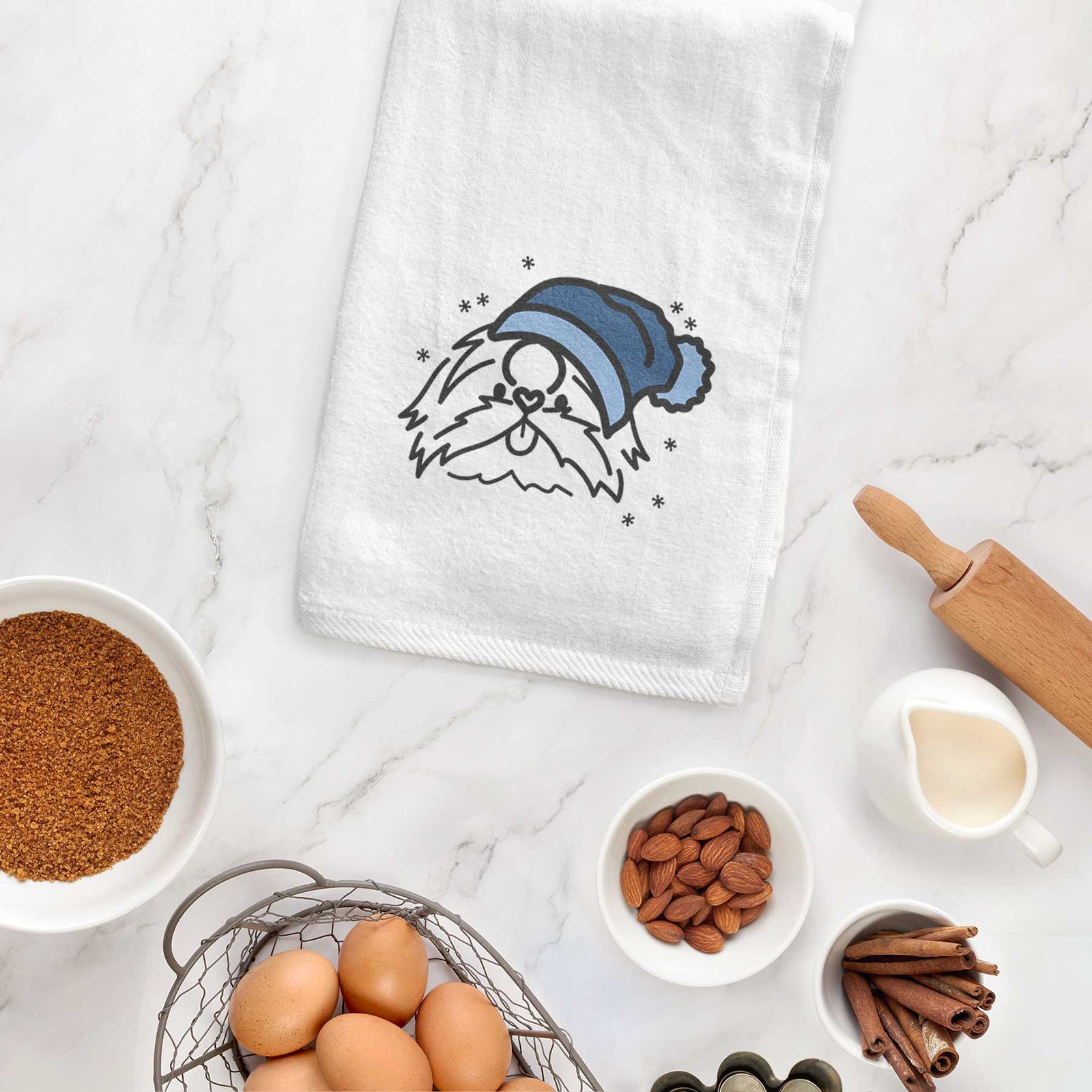 Minimalist line drawing of CoCo the Shih Tzu wearing a winter beanie on a decorative hand towel