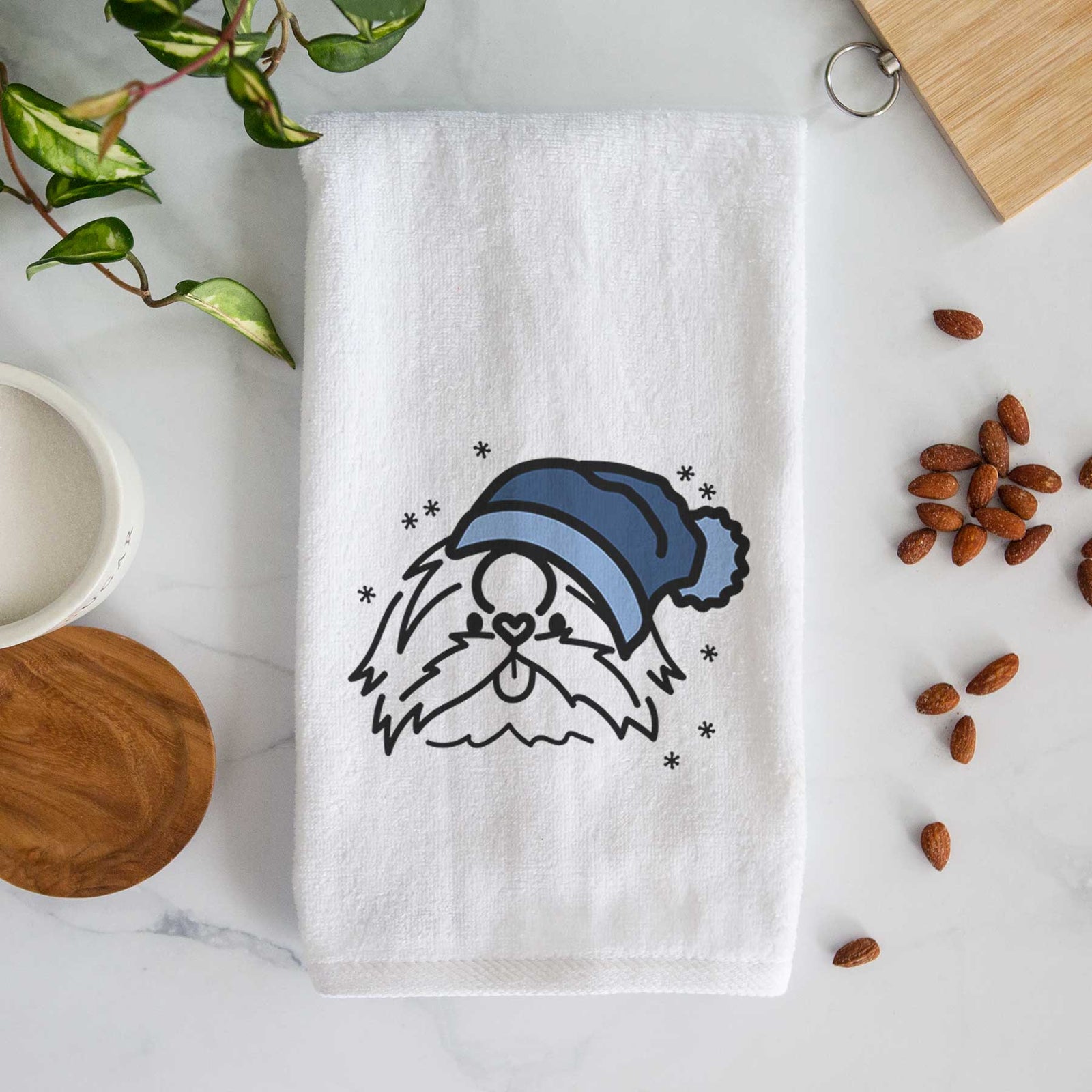 Minimalist line drawing of CoCo the Shih Tzu wearing a winter beanie on a decorative hand towel