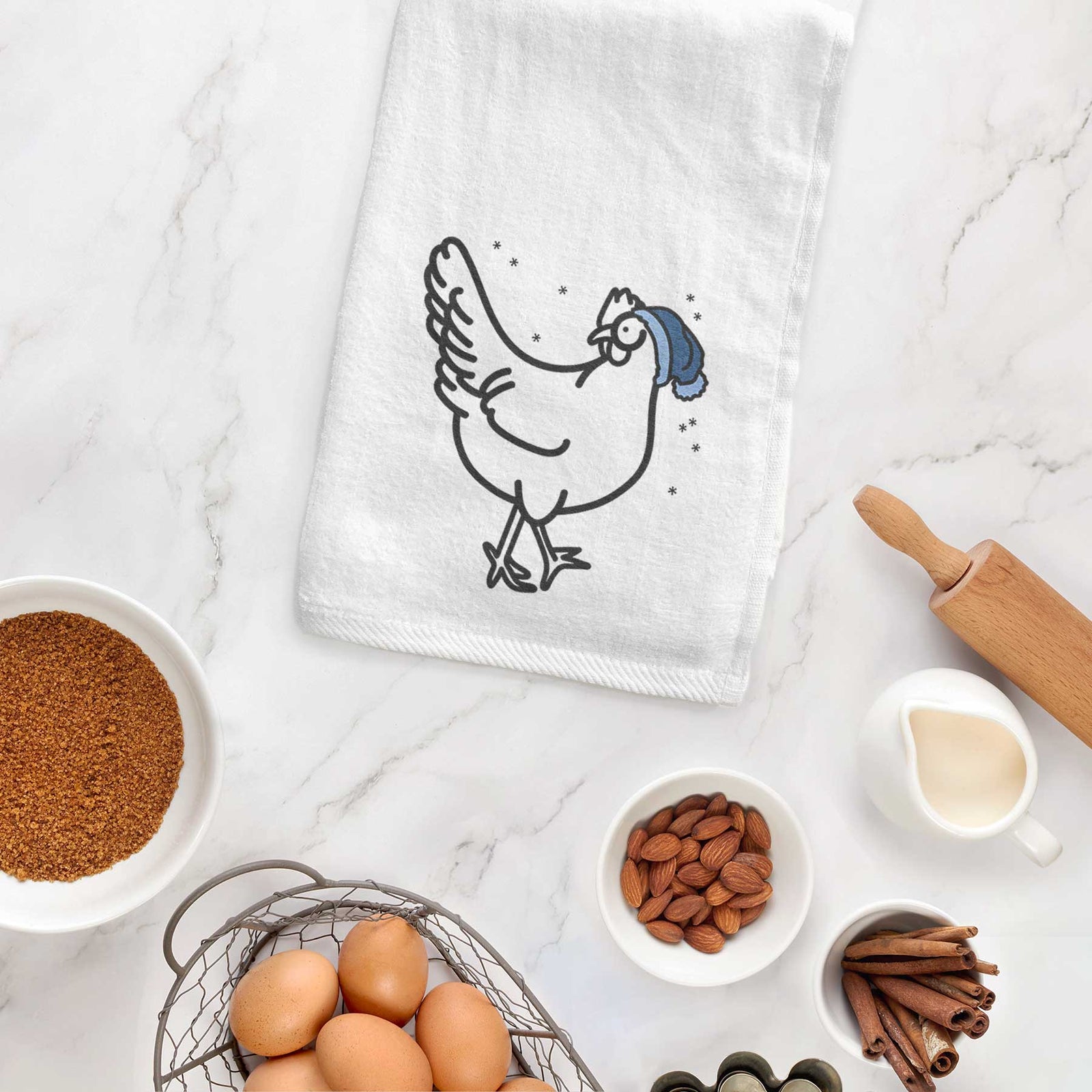 Minimalist line drawing of Daisy the Chicken wearing a winter beanie on a decorative hand towel