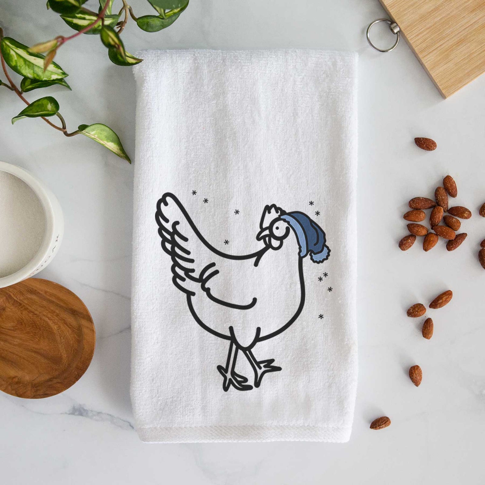 Minimalist line drawing of Daisy the Chicken wearing a winter beanie on a decorative hand towel