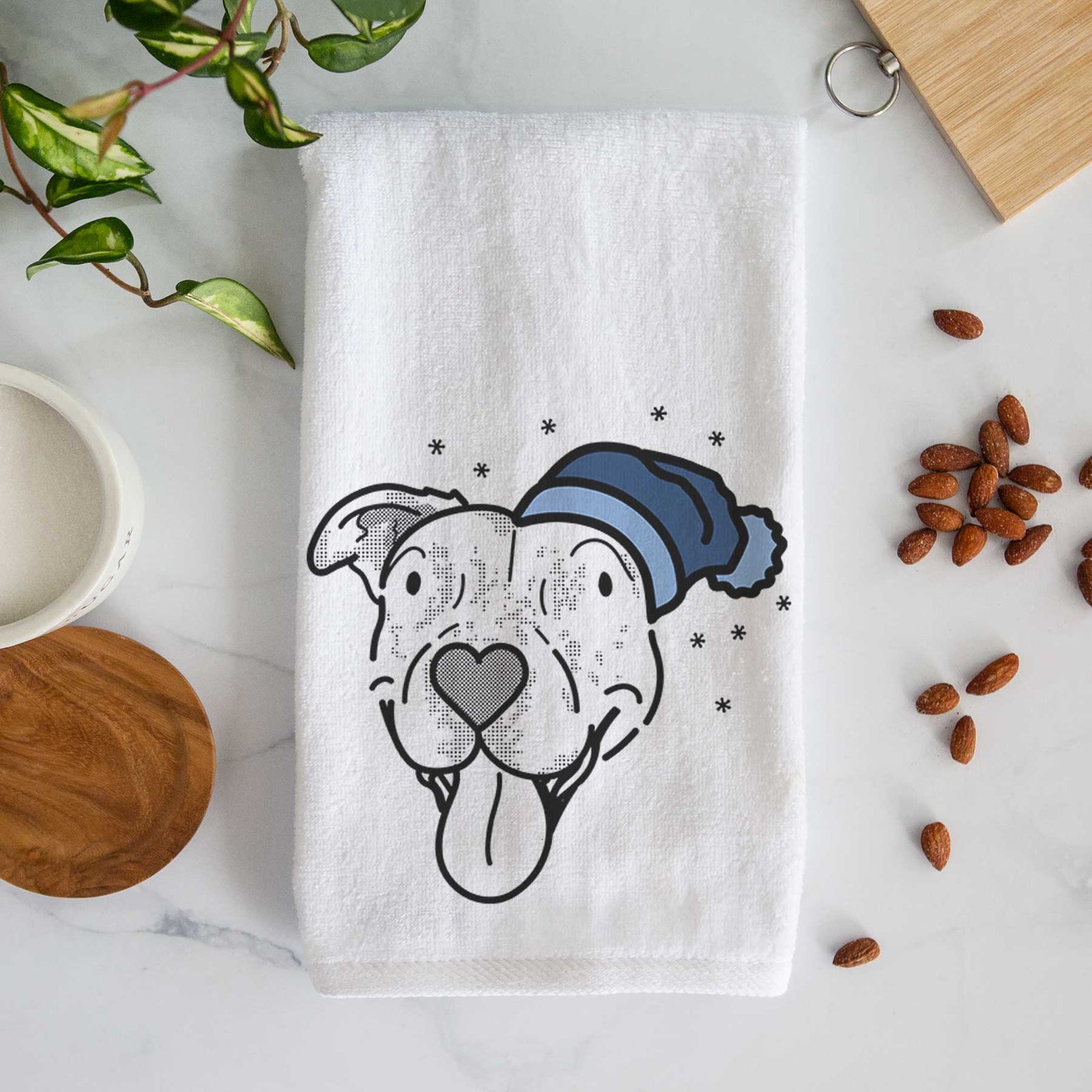 Minimalist line drawing of Dottie the Pitbull Mix wearing a winter beanie on a decorative hand towel