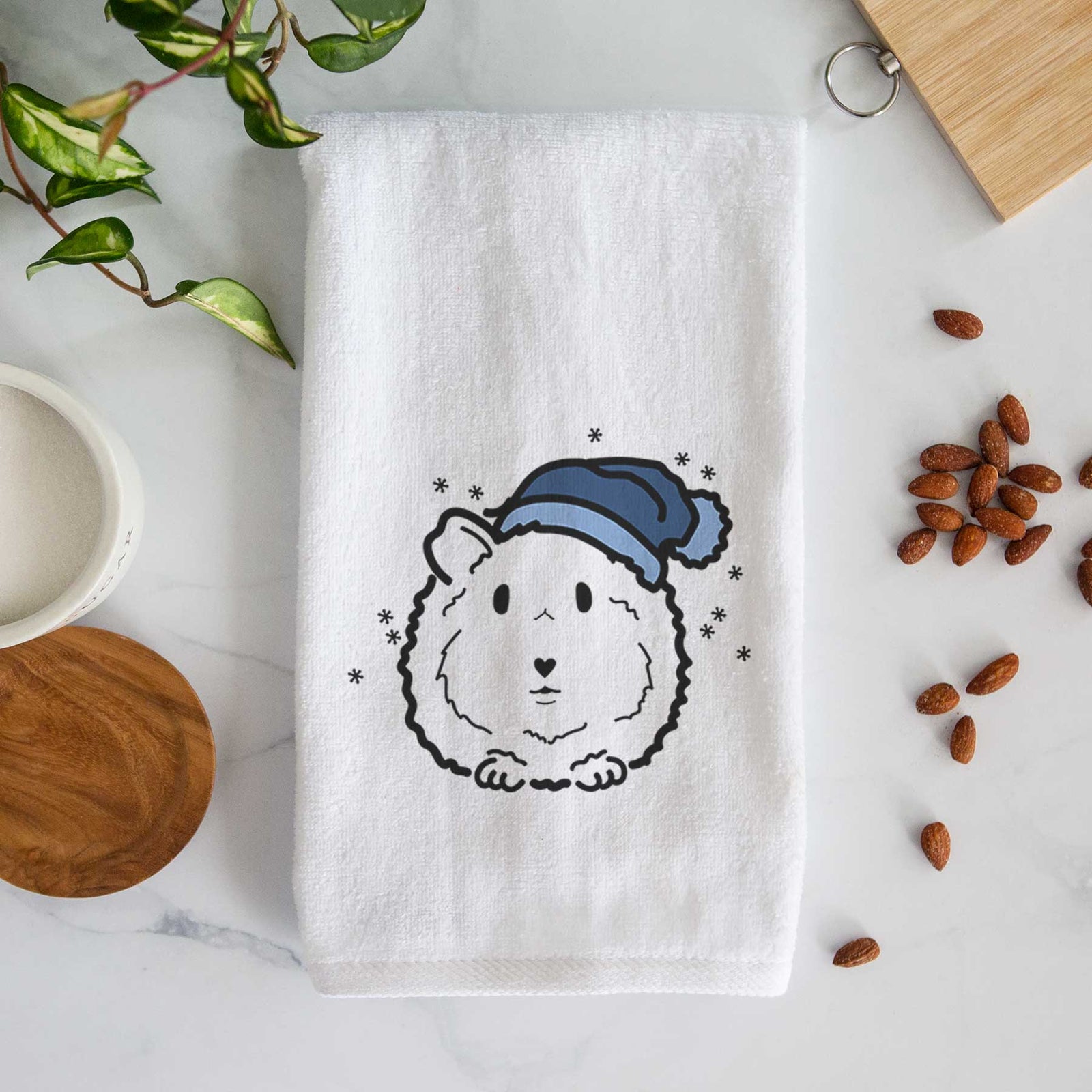 Minimalist line drawing of Duke the Guinea Pig wearing a winter beanie on a decorative hand towel