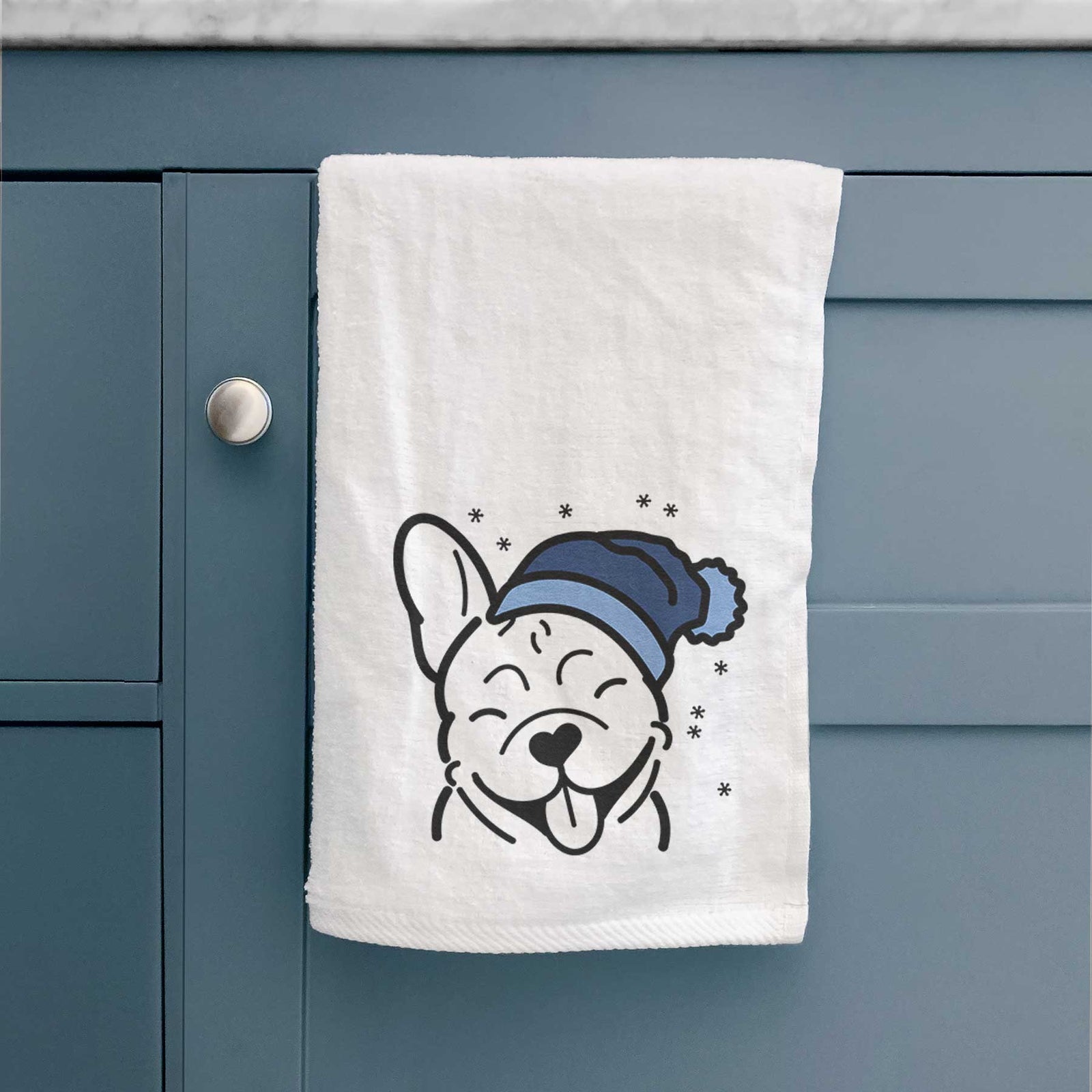 Minimalist line drawing of a French Bulldog wearing a winter beanie on a decorative hand towel