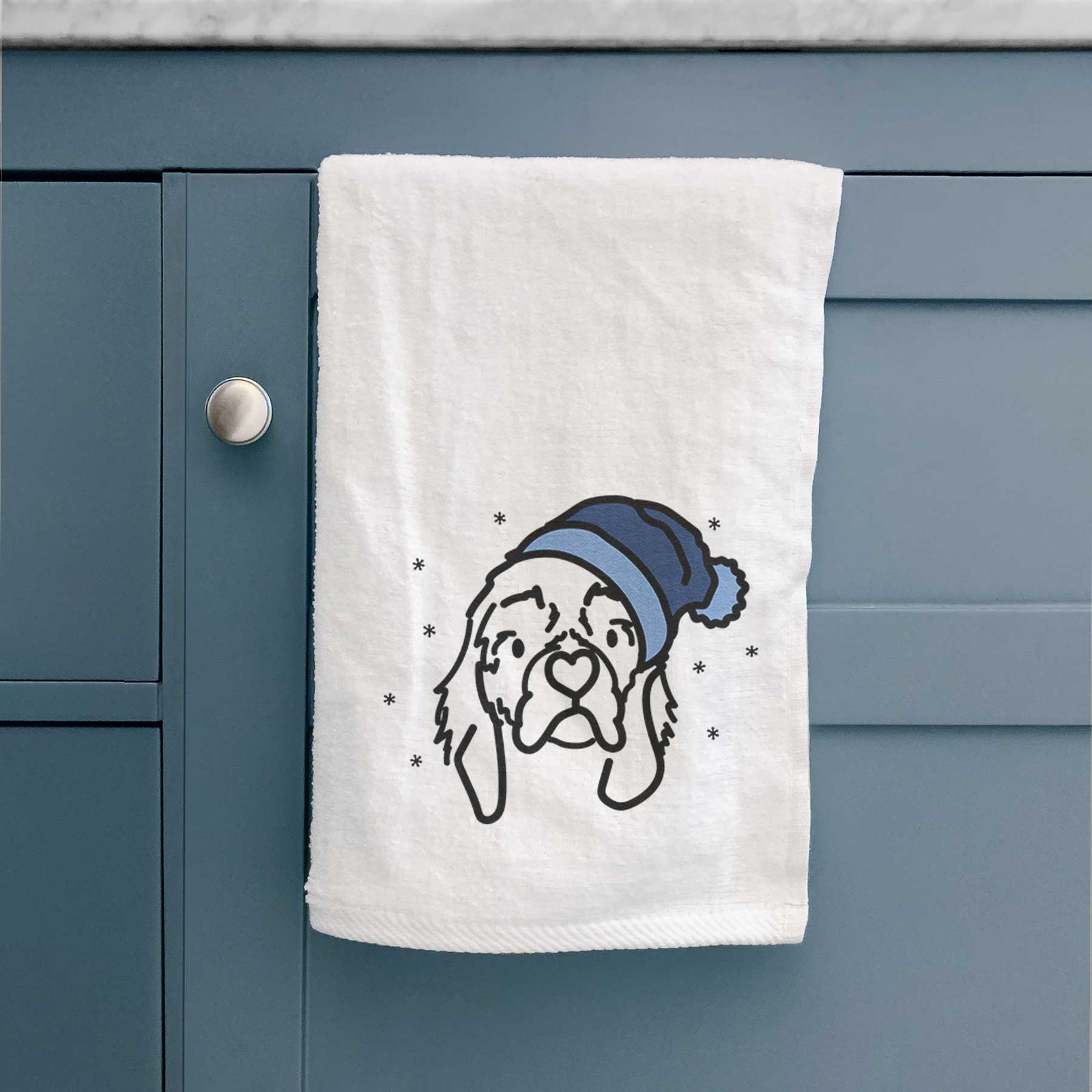 Minimalist line drawing of GiGi the Cocker Spaniel wearing a winter beanie on a decorative hand towel