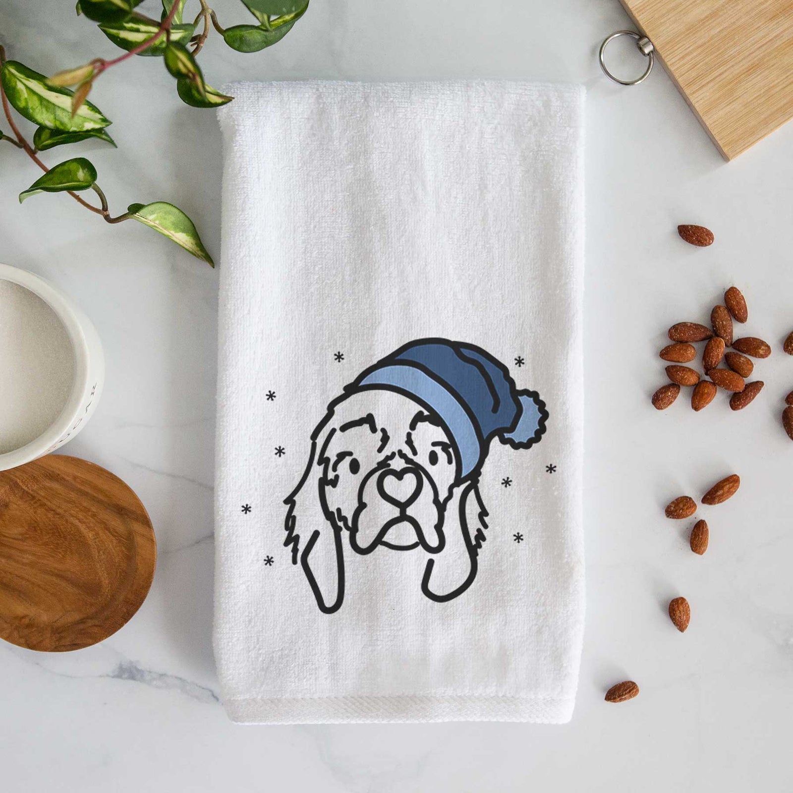 Minimalist line drawing of GiGi the Cocker Spaniel wearing a winter beanie on a decorative hand towel