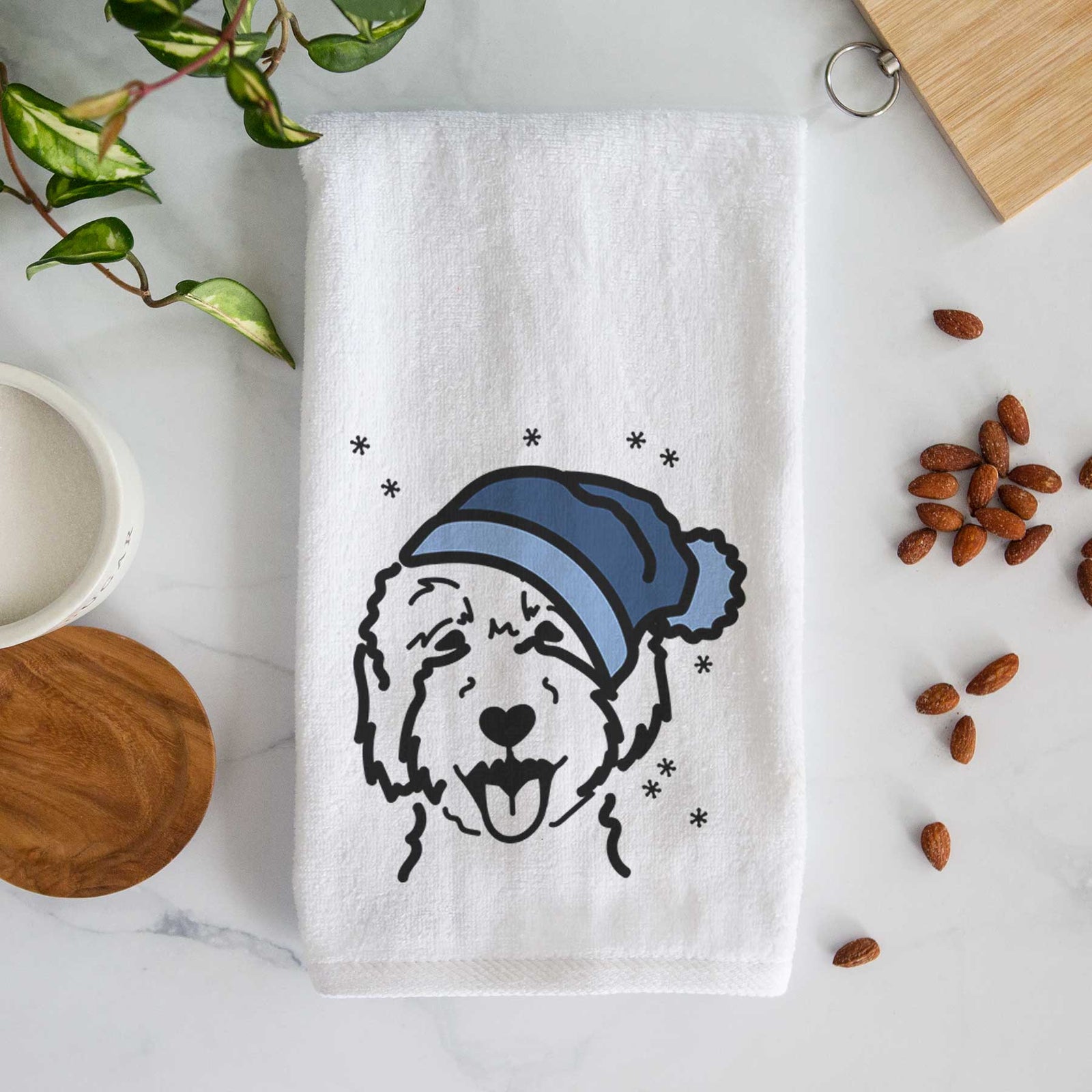 Minimalist line drawing of a Goldendoodle 2 wearing a winter beanie on a decorative hand towel