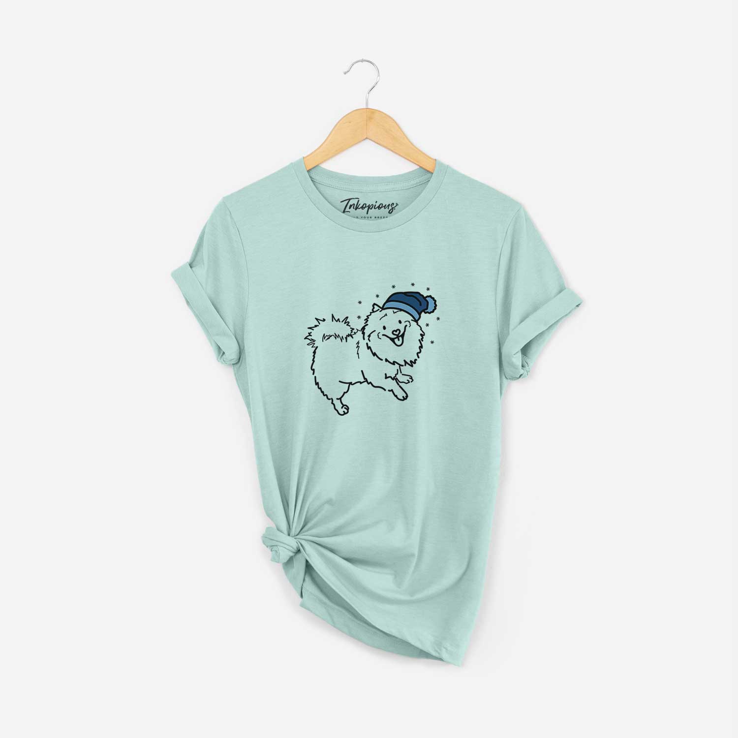 Minimalist line drawing of Goldie the Pomeranian Mix wearing a winter beanie on a Heather Sage Unisex crewneck