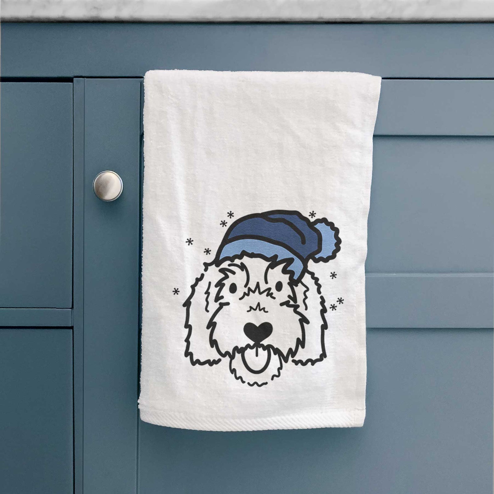 Minimalist line drawing of Gus the Goldendoodle wearing a winter beanie on a decorative hand towel