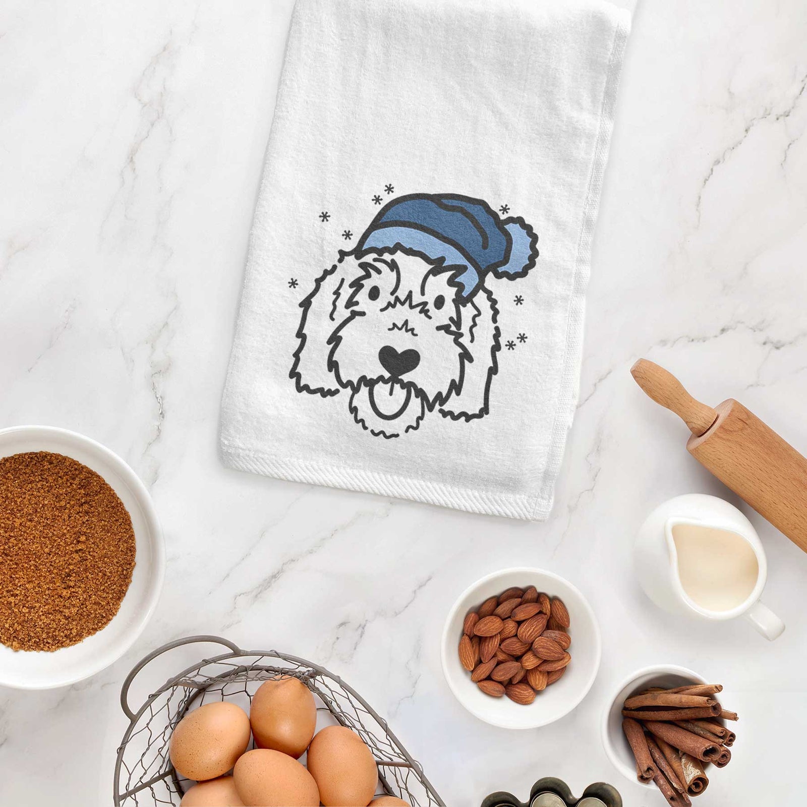 Minimalist line drawing of Gus the Goldendoodle wearing a winter beanie on a decorative hand towel