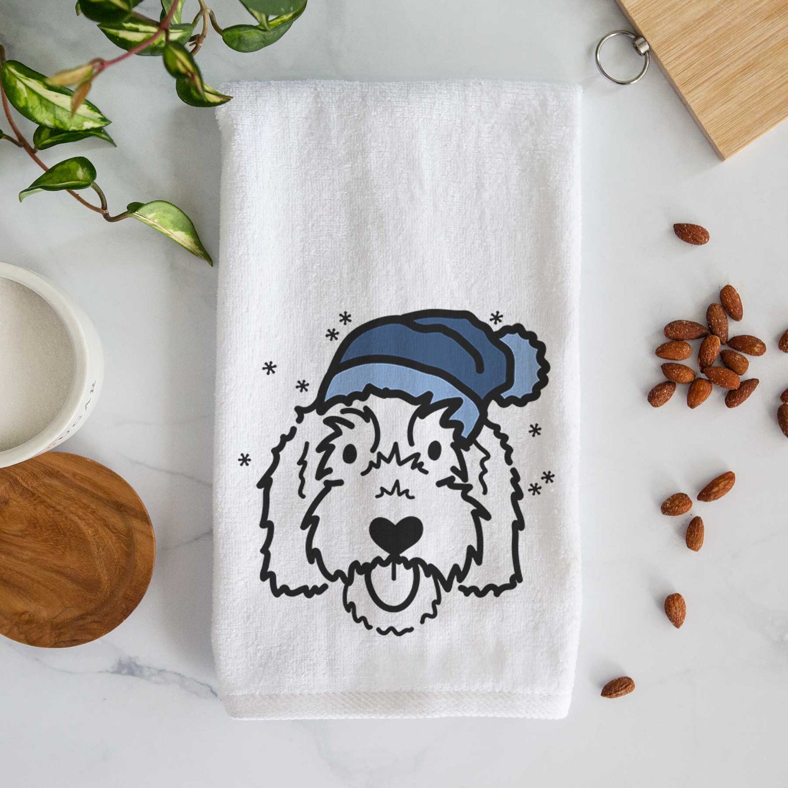 Minimalist line drawing of Gus the Goldendoodle wearing a winter beanie on a decorative hand towel
