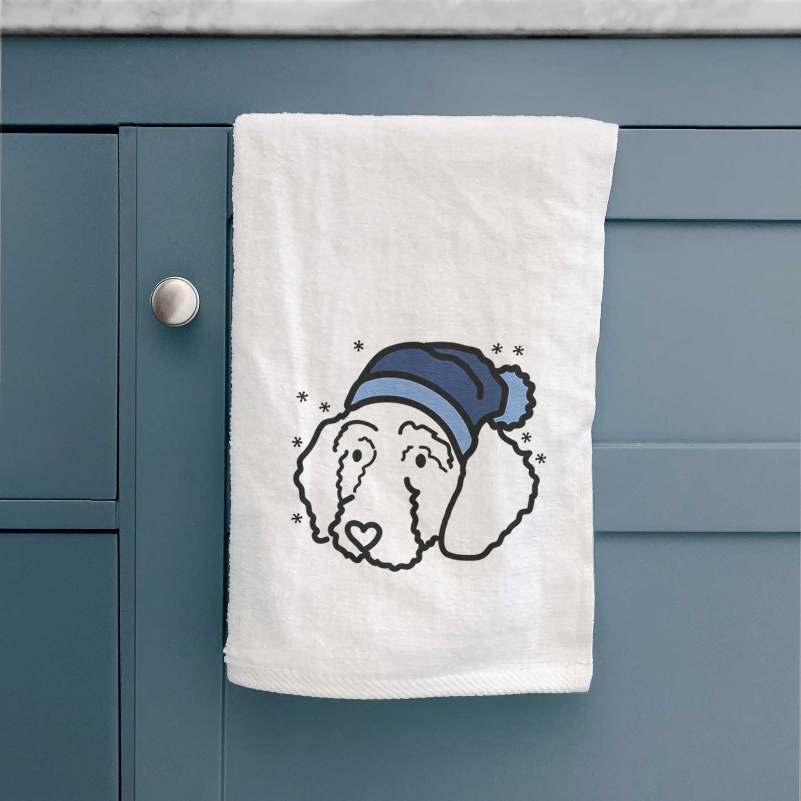 Minimalist line drawing of Hanna the Goldendoodle wearing a winter beanie on a decorative hand towel