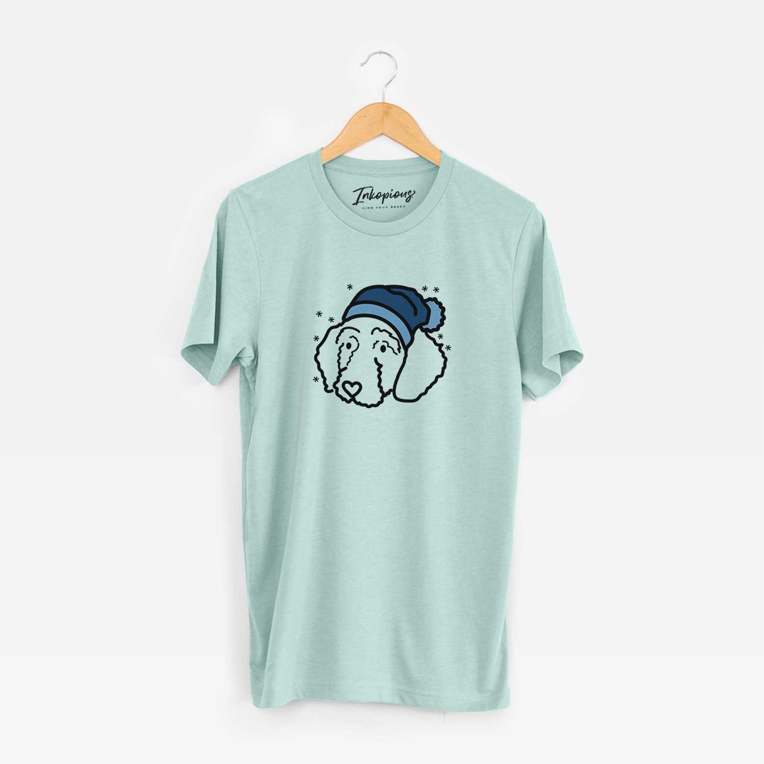 Minimalist line drawing of Hanna the Goldendoodle wearing a winter beanie on a Heather Sage Unisex crewneck