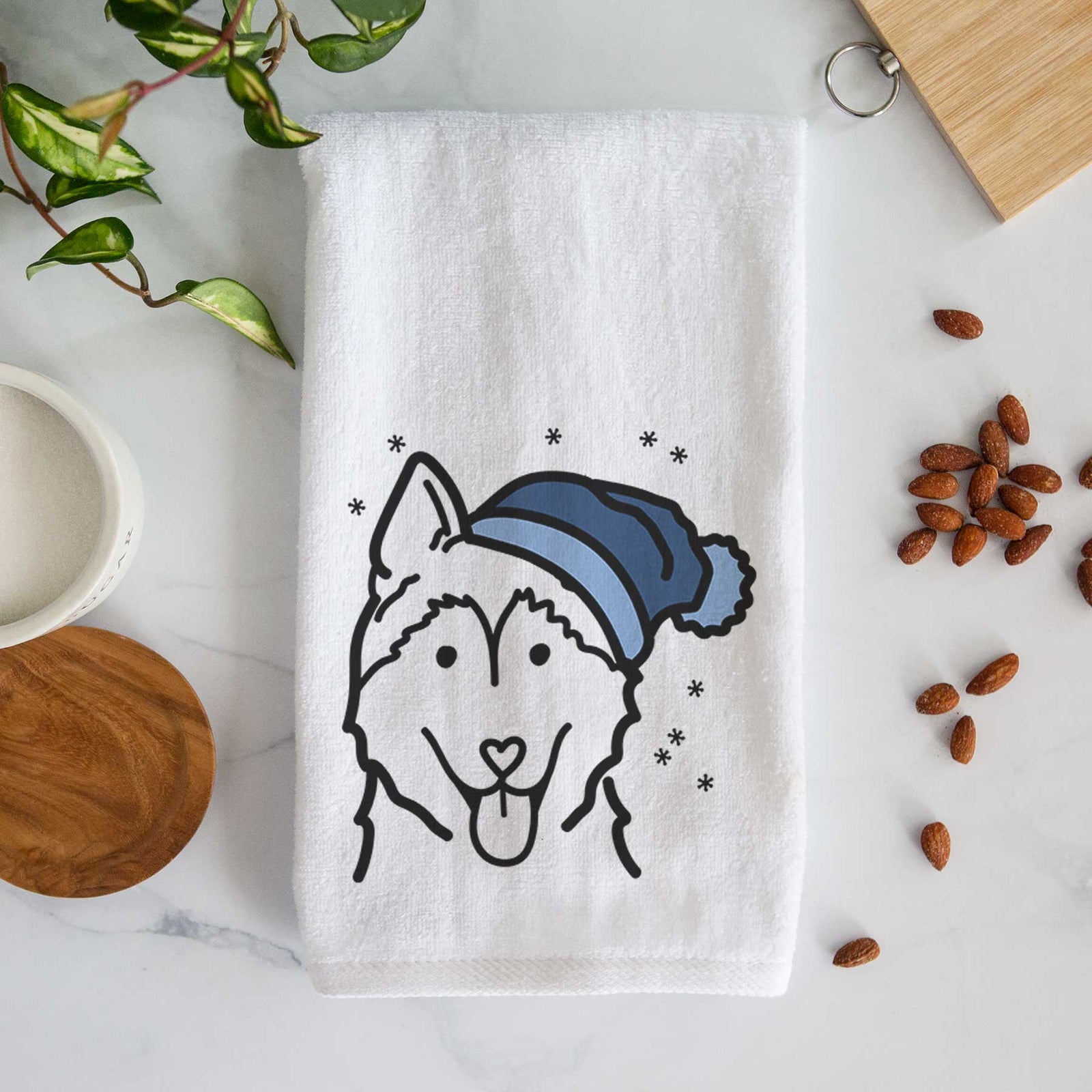 Minimalist line drawing of a Siberian Husky wearing a winter beanie on a decorative hand towel