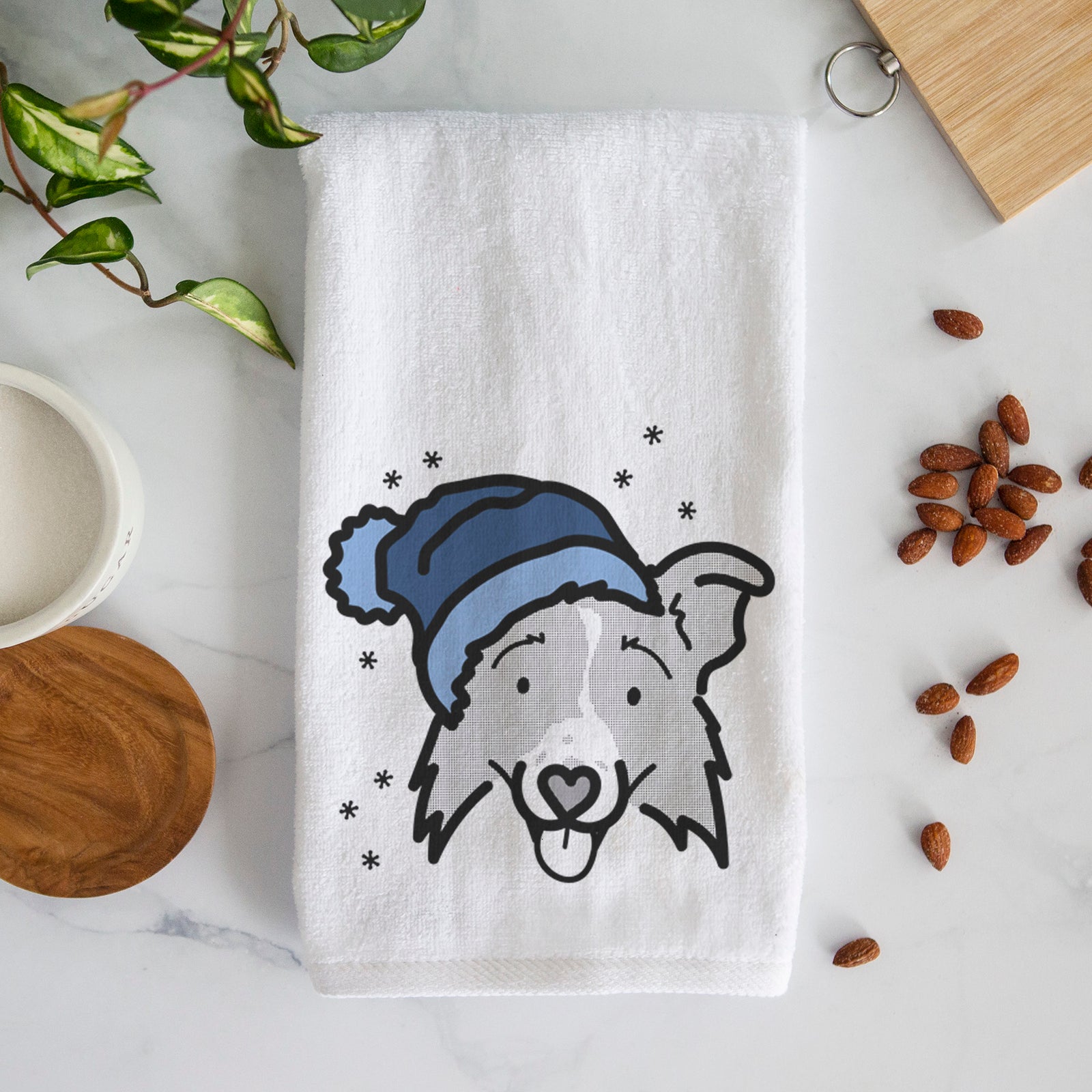 Minimalist line drawing of Jam the Border Collie 2.0 wearing a winter beanie on a decorative hand towel
