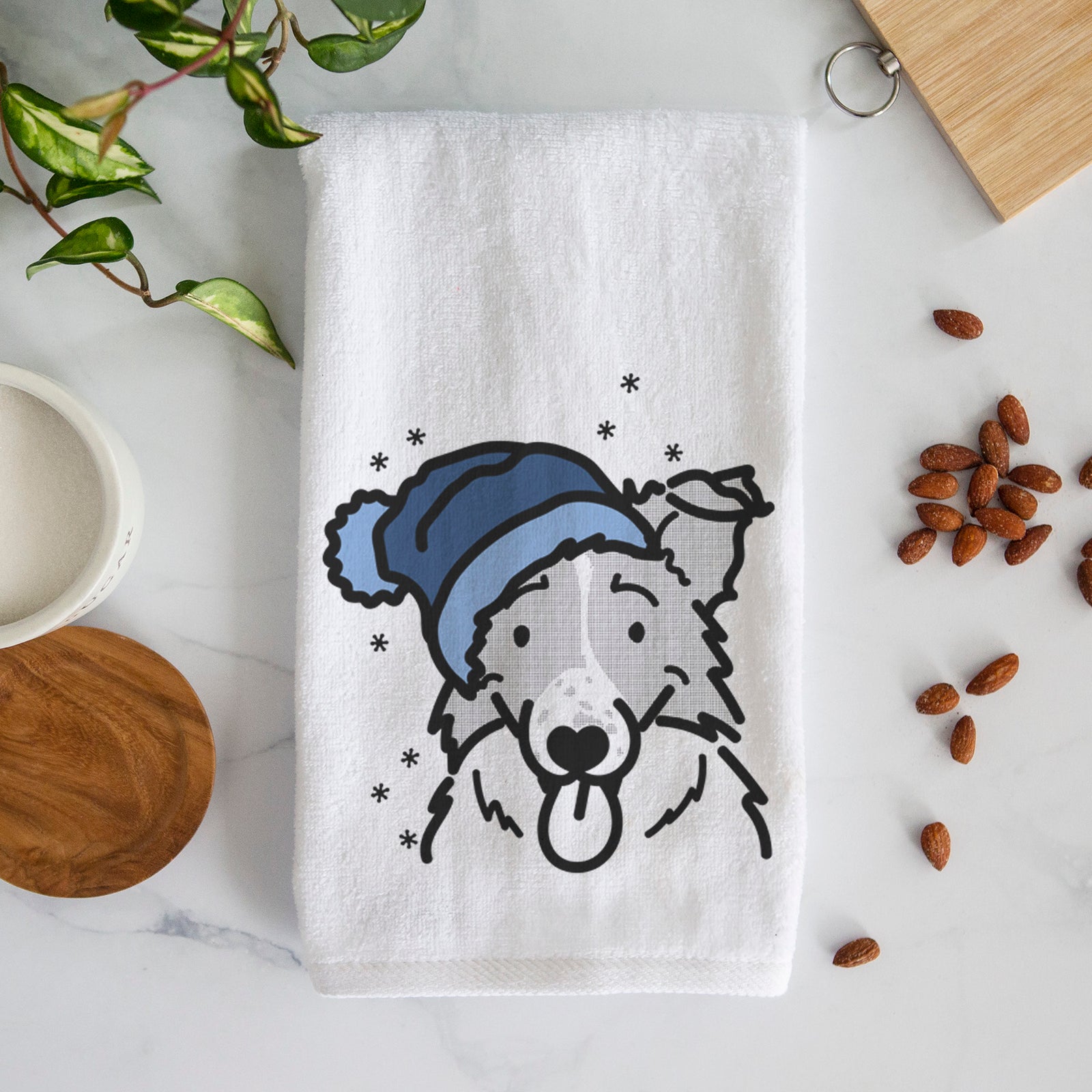 Minimalist line drawing of Jam the Border Collie wearing a winter beanie on a decorative hand towel
