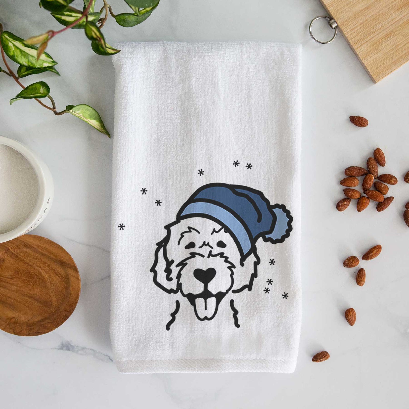 Minimalist line drawing of a Labradoodle wearing a winter beanie on a decorative hand towel