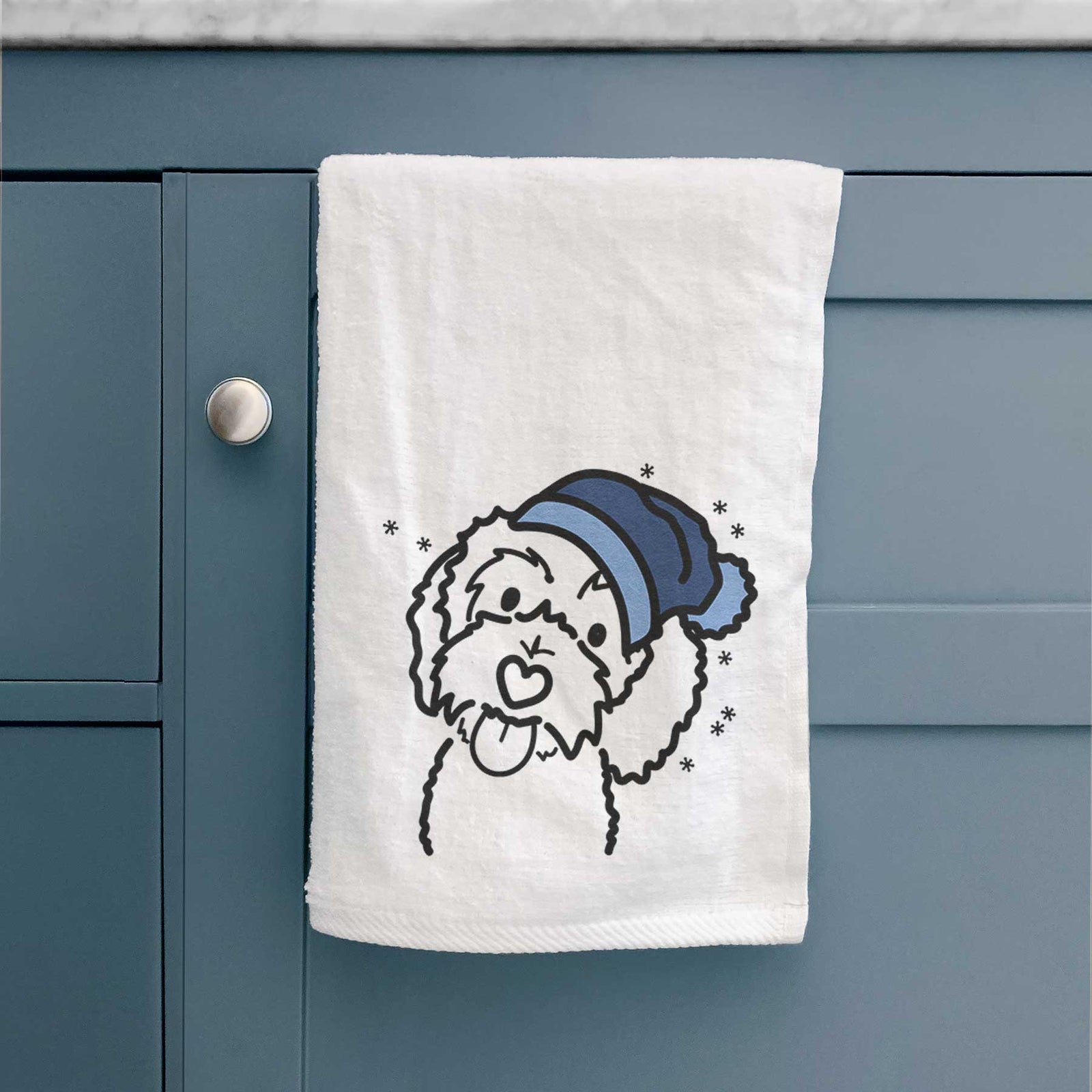 Minimalist line drawing of Mabel the Bernedoodle wearing a winter beanie on a decorative hand towel