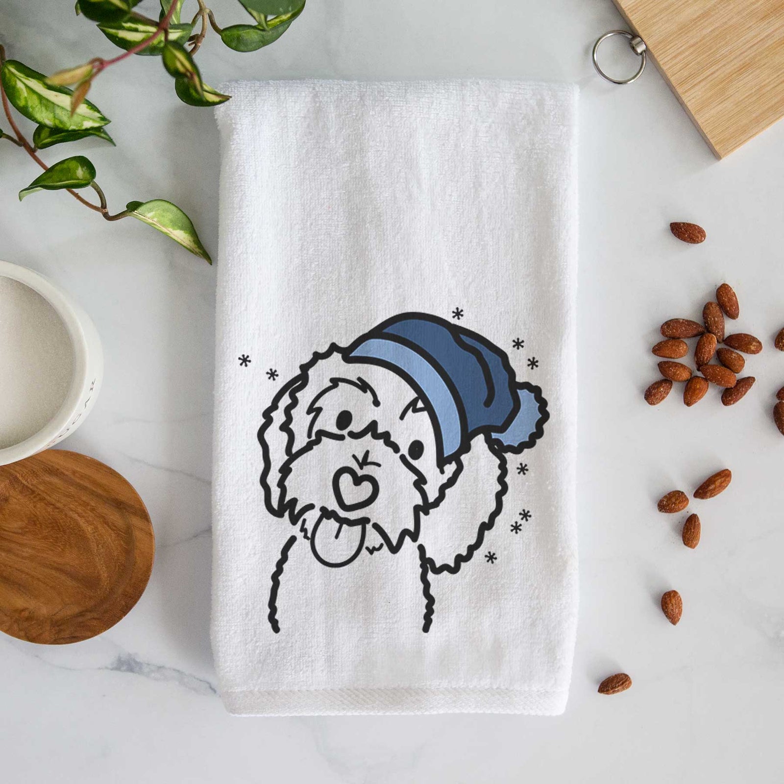 Minimalist line drawing of Mabel the Bernedoodle wearing a winter beanie on a decorative hand towel