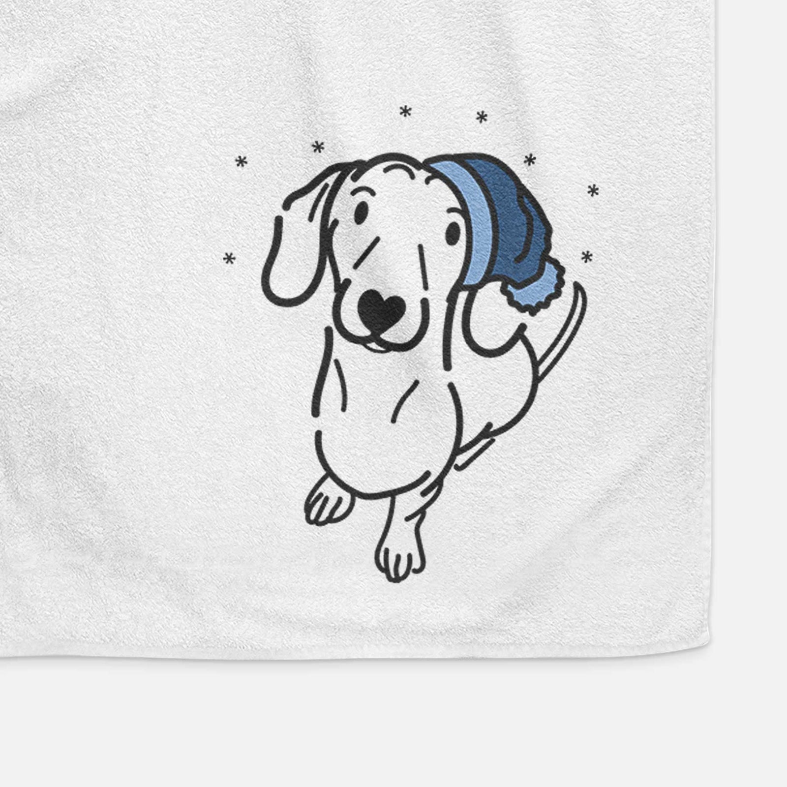 Minimalist line drawing of Moxie the Dachshund wearing a winter beanie on a decorative hand towel