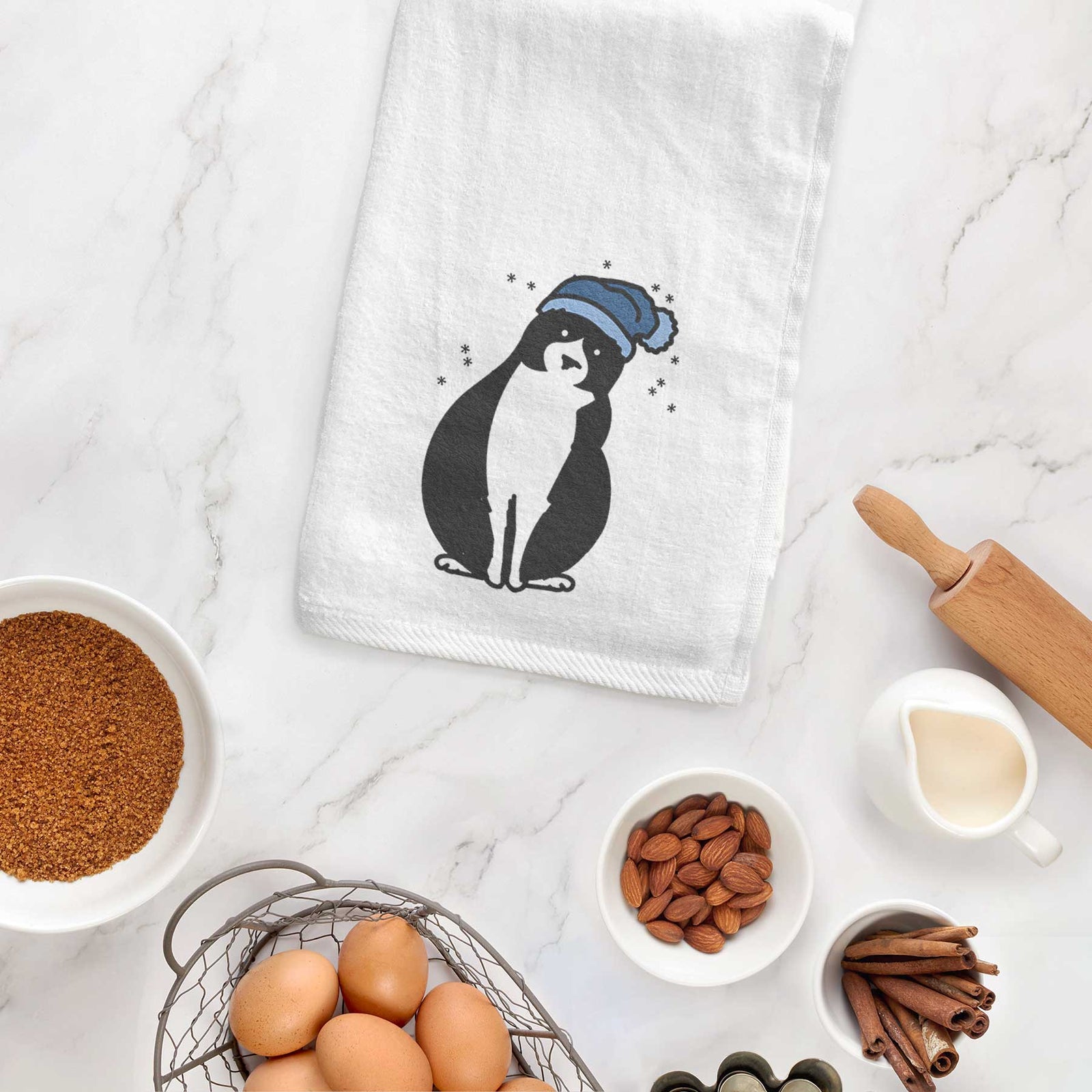 Minimalist line drawing of Oliver the Tuxedo Cat wearing a winter beanie on a decorative hand towel