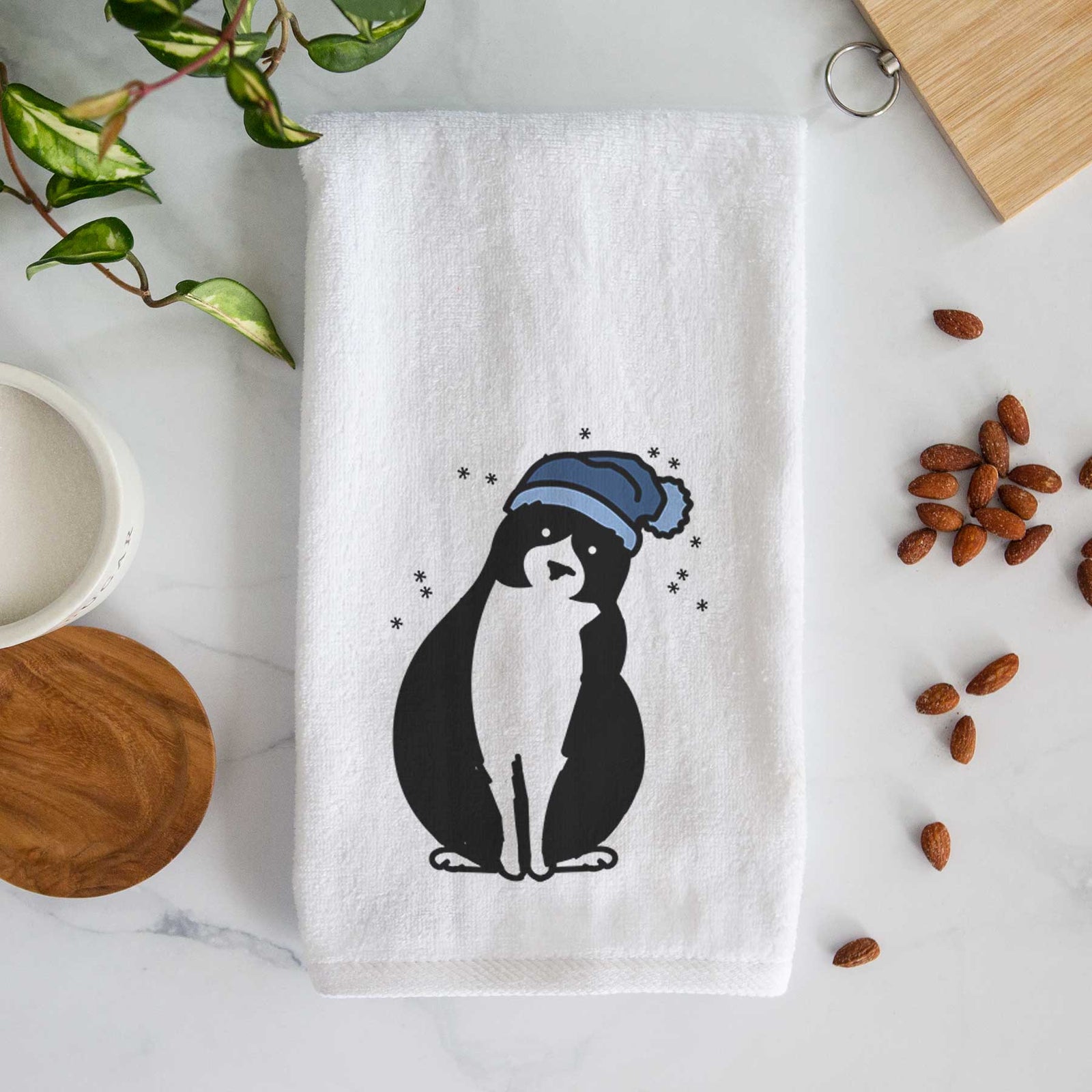 Minimalist line drawing of Oliver the Tuxedo Cat wearing a winter beanie on a decorative hand towel