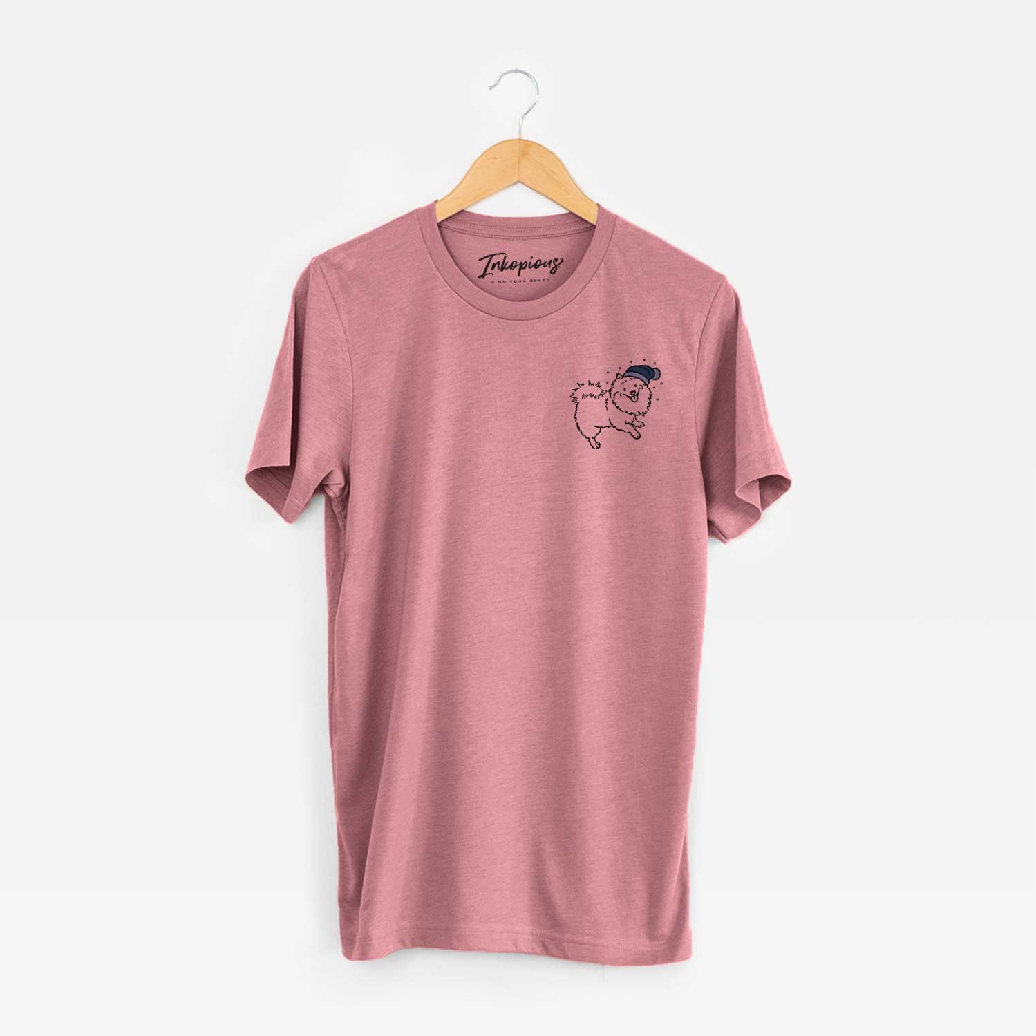 Small chest-pocket minimalist line drawing of Goldie the Pomeranian Mix wearing a winter beanie on a Mauve Unisex crewneck