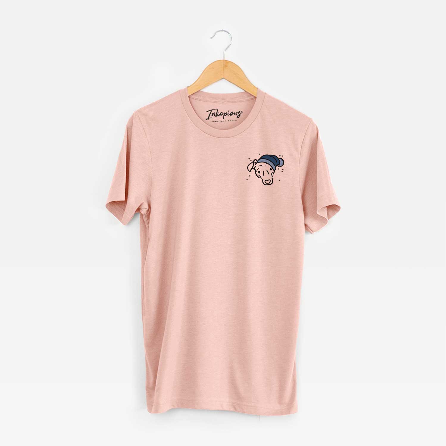 Small chest-pocket minimalist line drawing of Millie the Mixed Breed wearing a winter beanie on a Peach Unisex crewneck