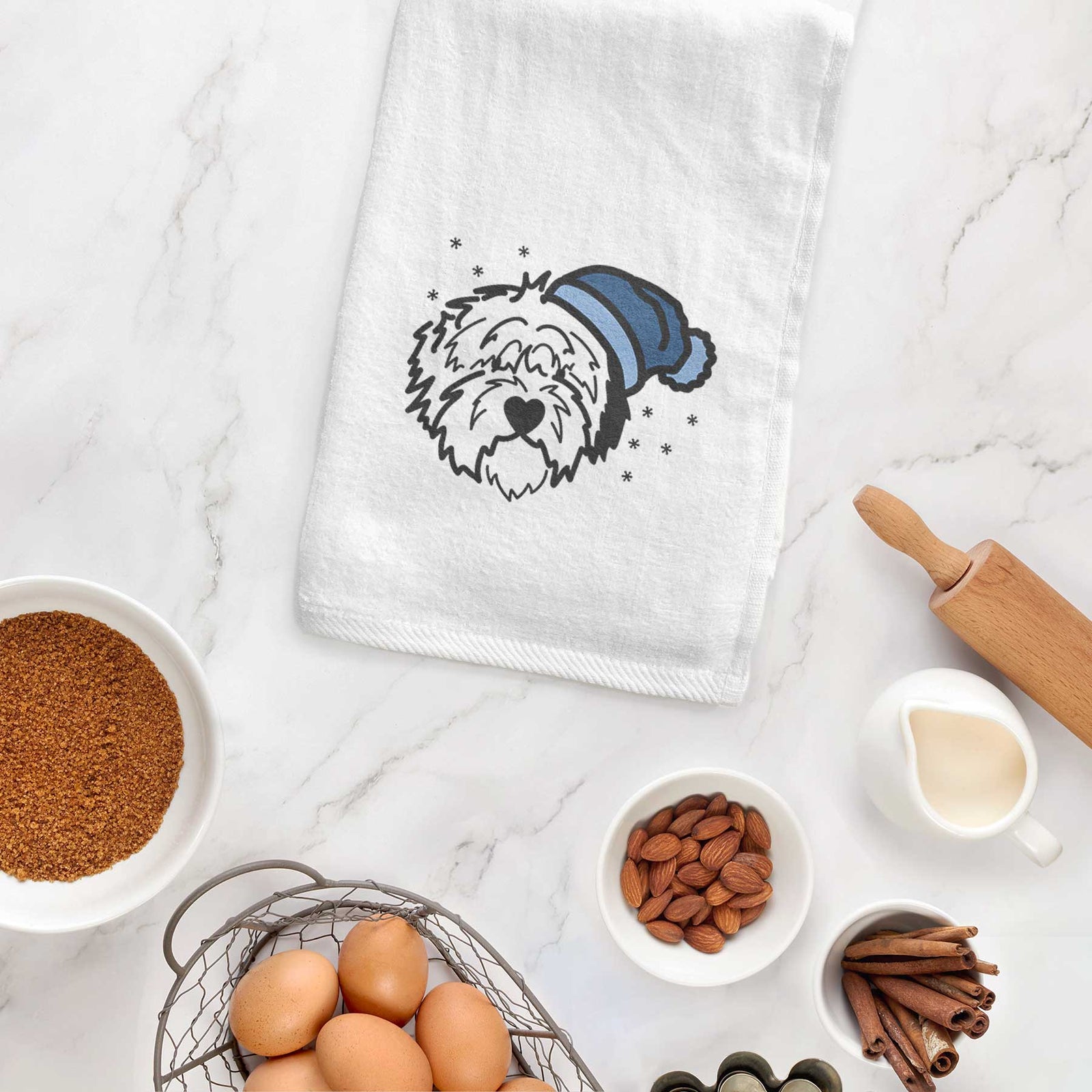 Minimalist line drawing of Penny the Old English Sheepdog wearing a winter beanie on a decorative hand towel
