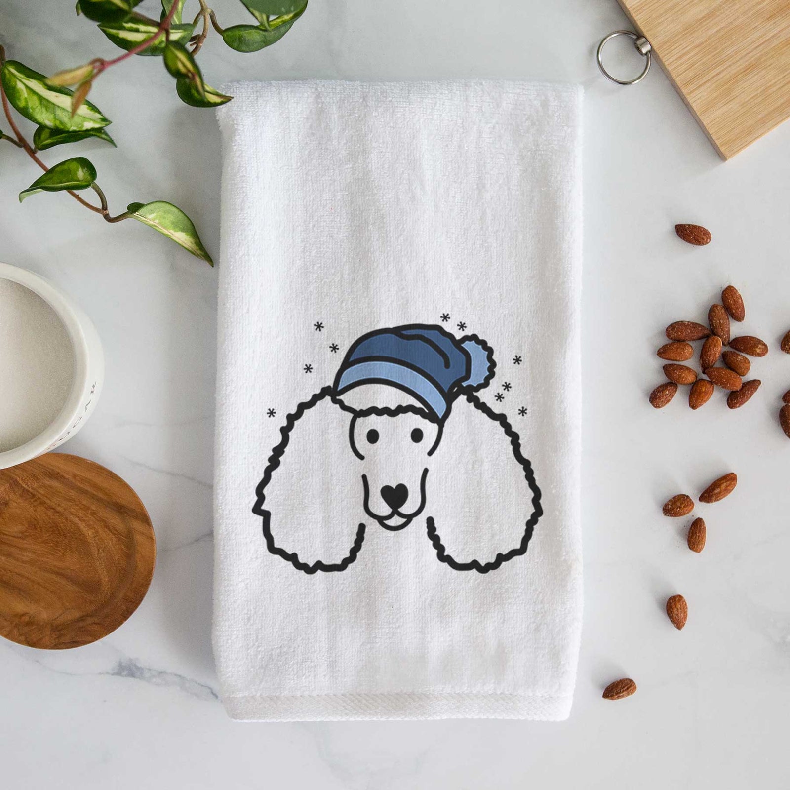 Minimalist line drawing of a Poodle wearing a winter beanie on a decorative hand towel