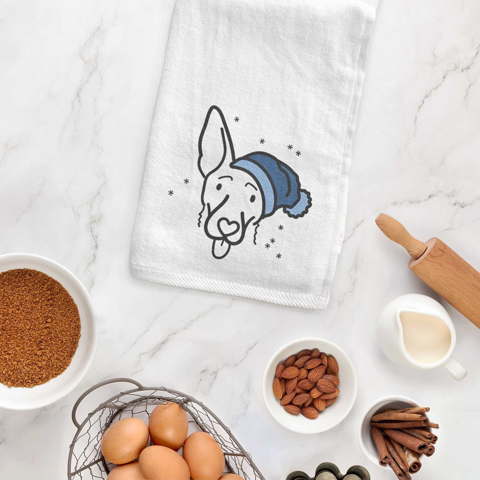 Minimalist line drawing of Rosie the Shepherd Mix wearing a winter beanie on a decorative hand towel