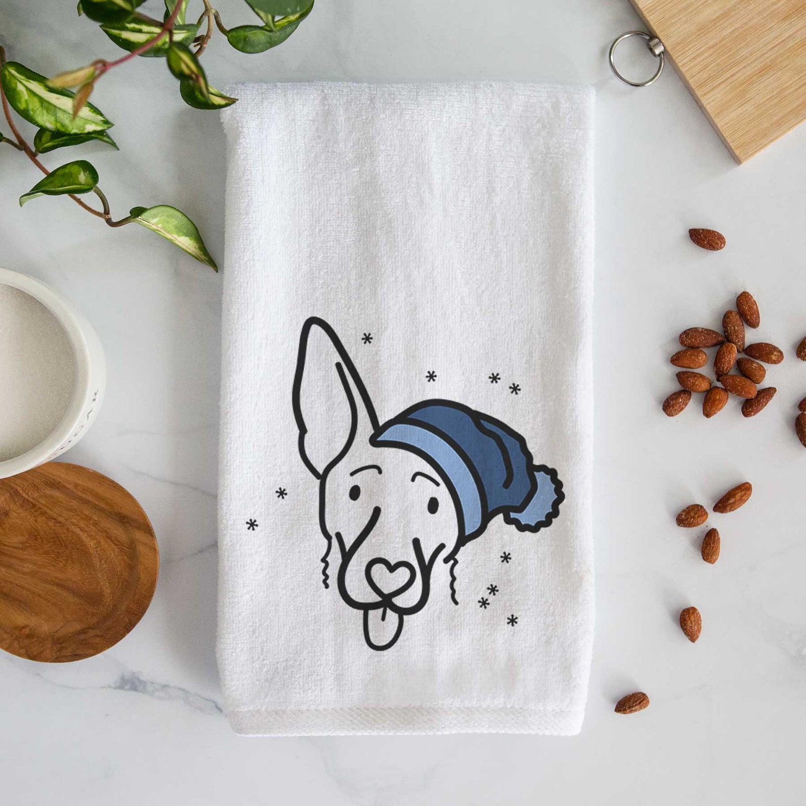 Minimalist line drawing of Rosie the Shepherd Mix wearing a winter beanie on a decorative hand towel