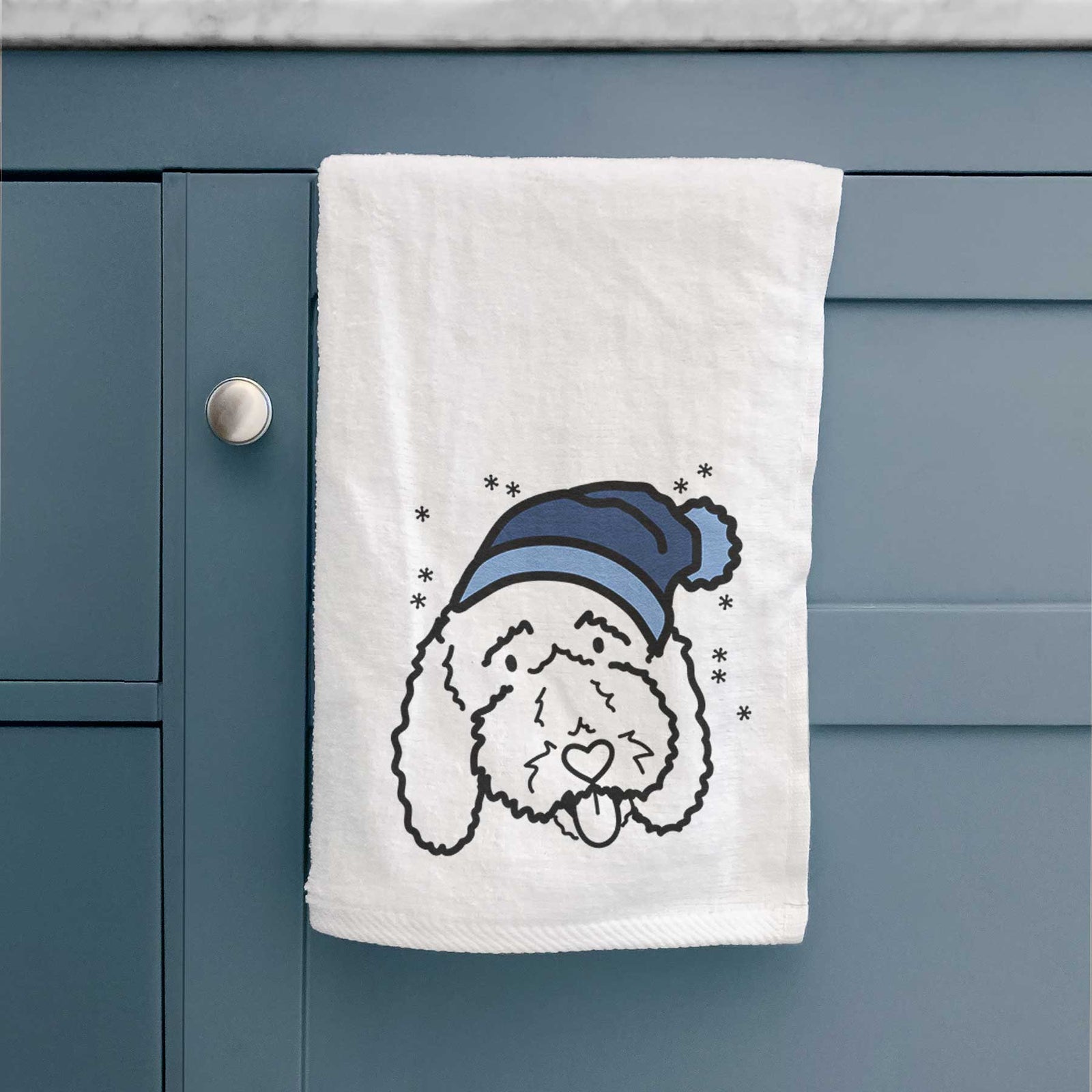 Minimalist line drawing of Ruby the Bernedoodle wearing a winter beanie on a decorative hand towel