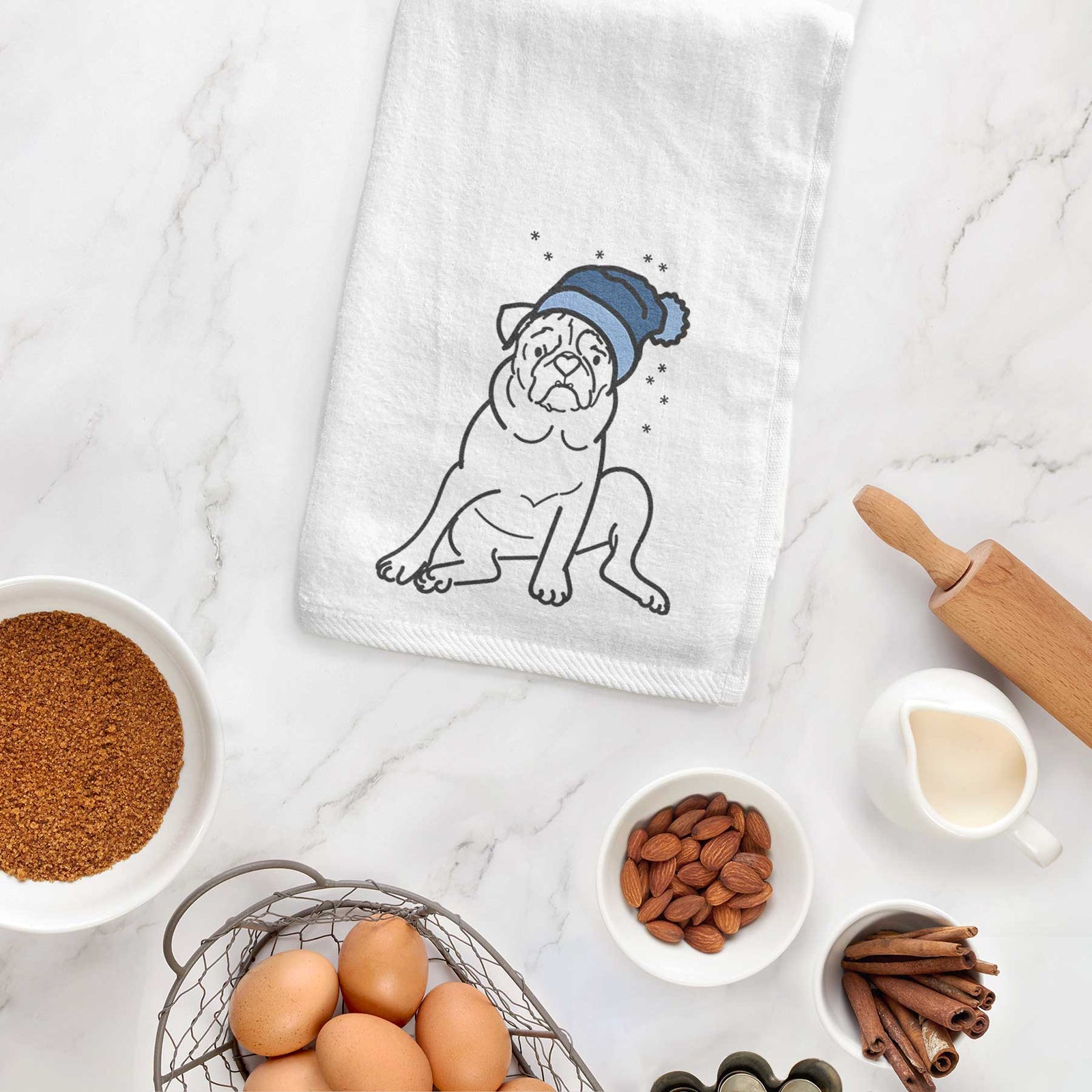 Minimalist line drawing of Rudy the Pug wearing a winter beanie on a decorative hand towel