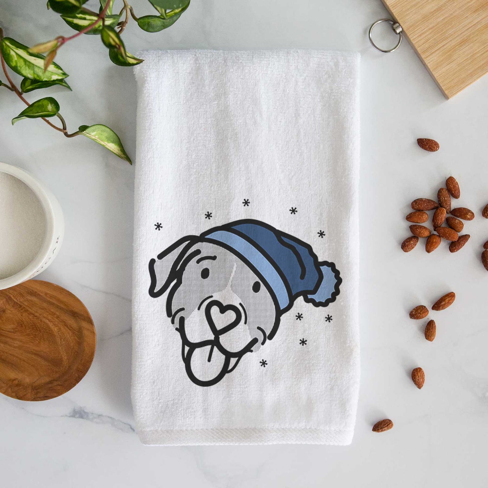 Minimalist line drawing of Shadow the Pitbull Mix wearing a winter beanie on a decorative hand towel