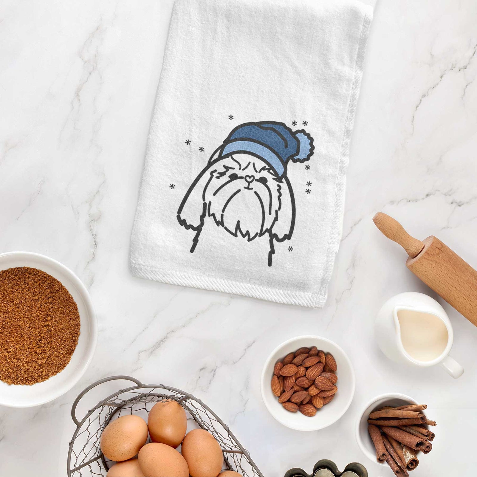 Minimalist line drawing of a Shih Tzu wearing a winter beanie on a decorative hand towel