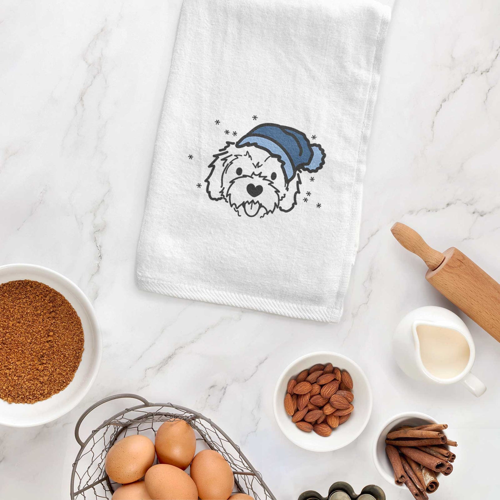 Minimalist line drawing of Sprinkles the Cockapoo wearing a winter beanie on a decorative hand towel
