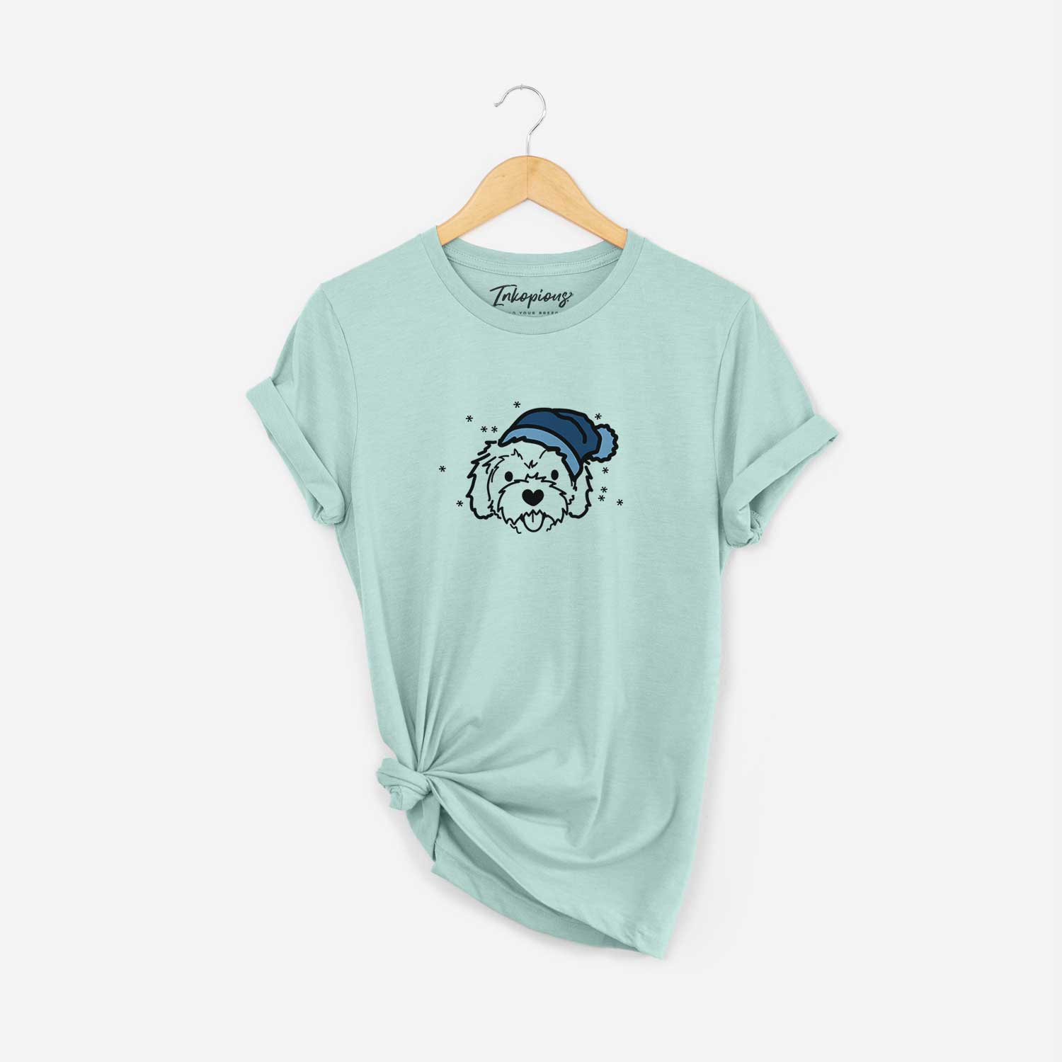 Minimalist line drawing of Sprinkles the Cockapoo wearing a winter beanie on a Heather Sage Unisex crewneck