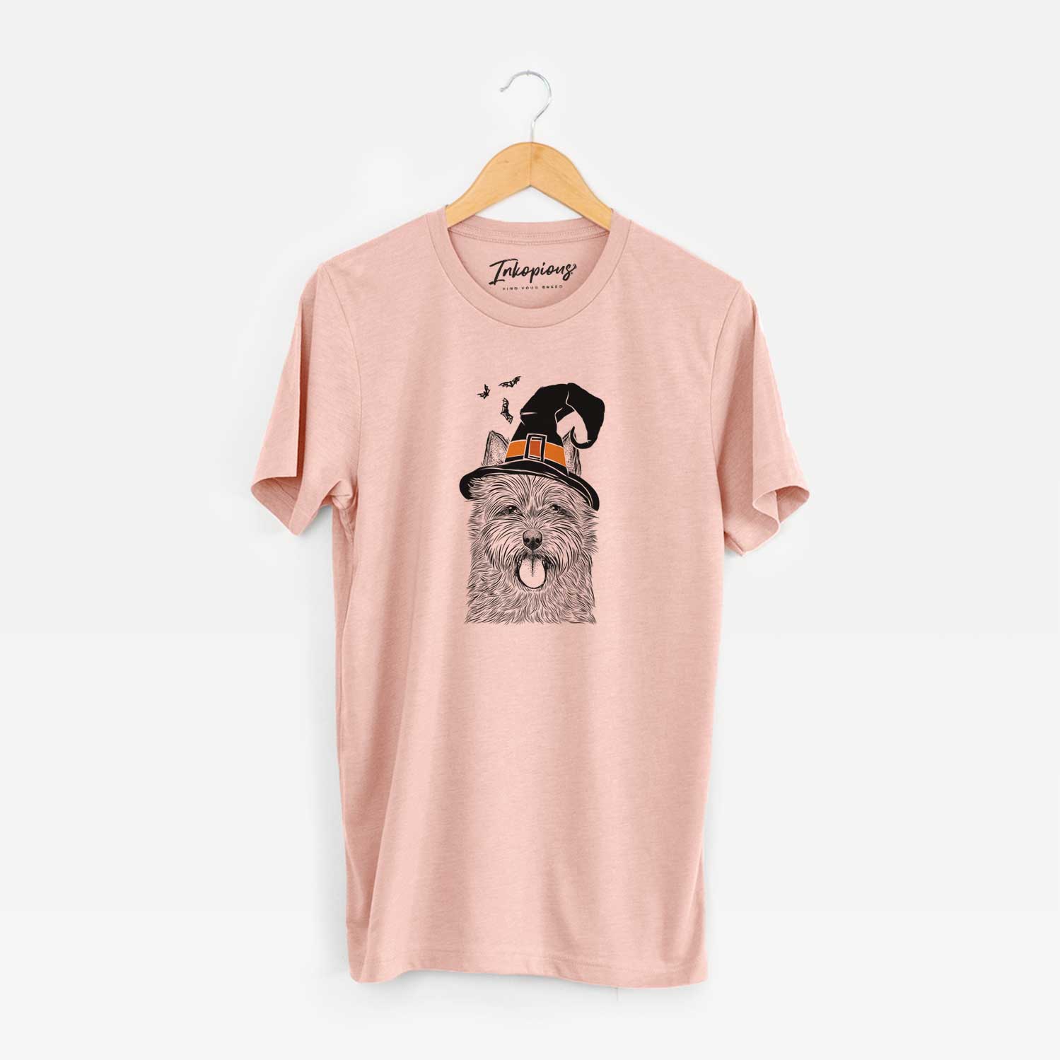 Hand-drawn sketch of Alfie the Norwich Terrier wearing a witch hat on a Peach Unisex crewneck
