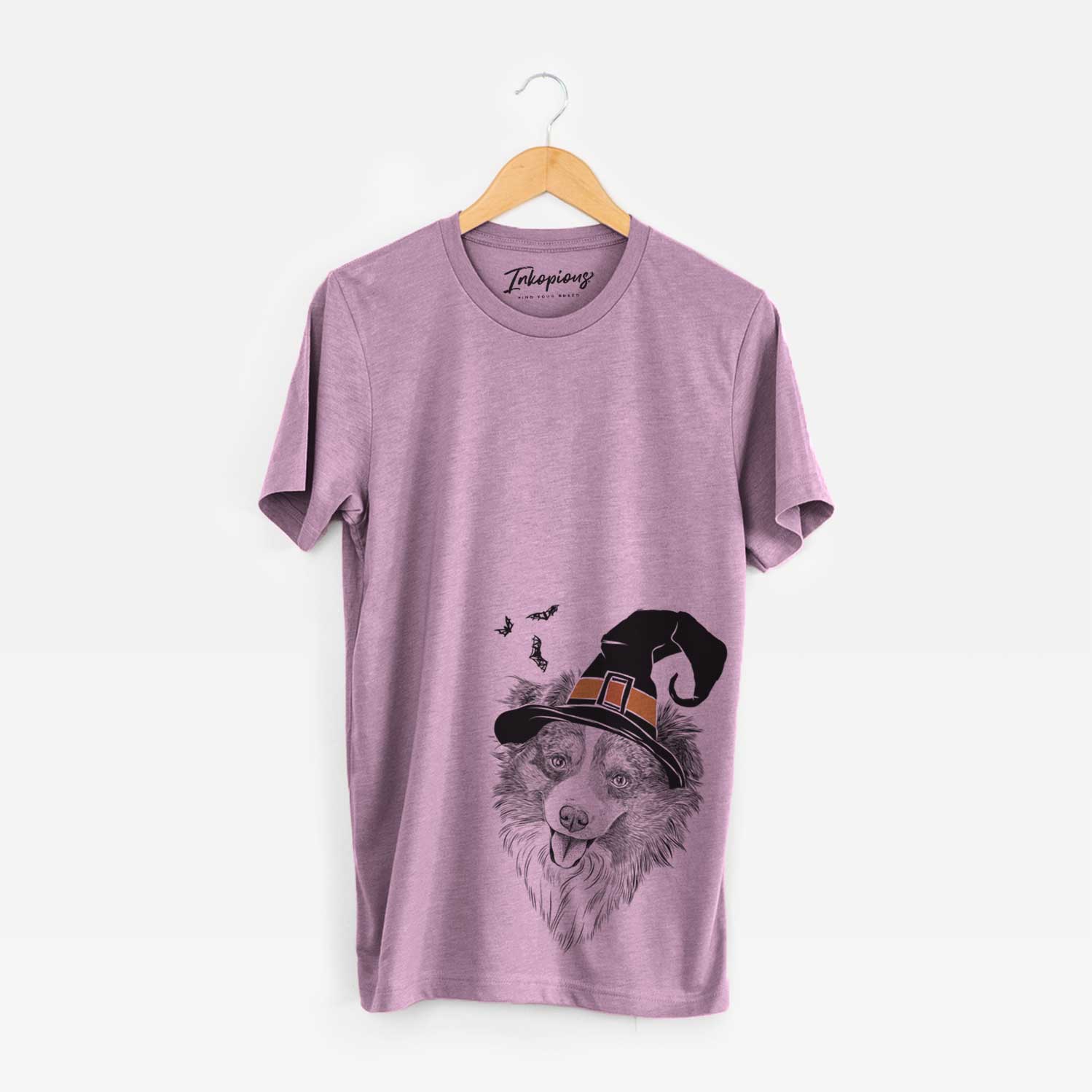 Hand-drawn sketch of Doc the Mini Aussie wearing a witch hat on an Orchid Unisex crewneck