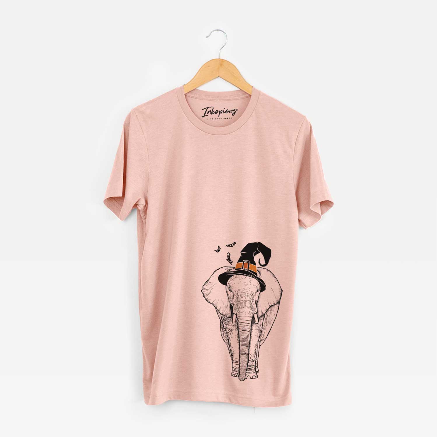 Hand-drawn sketch of Ella the Elephant wearing a witch hat on a Peach Unisex crewneck