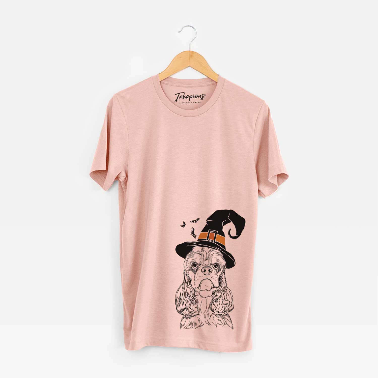 Hand-drawn sketch of Emma the Cocker Spaniel wearing a witch hat on a Peach Unisex crewneck
